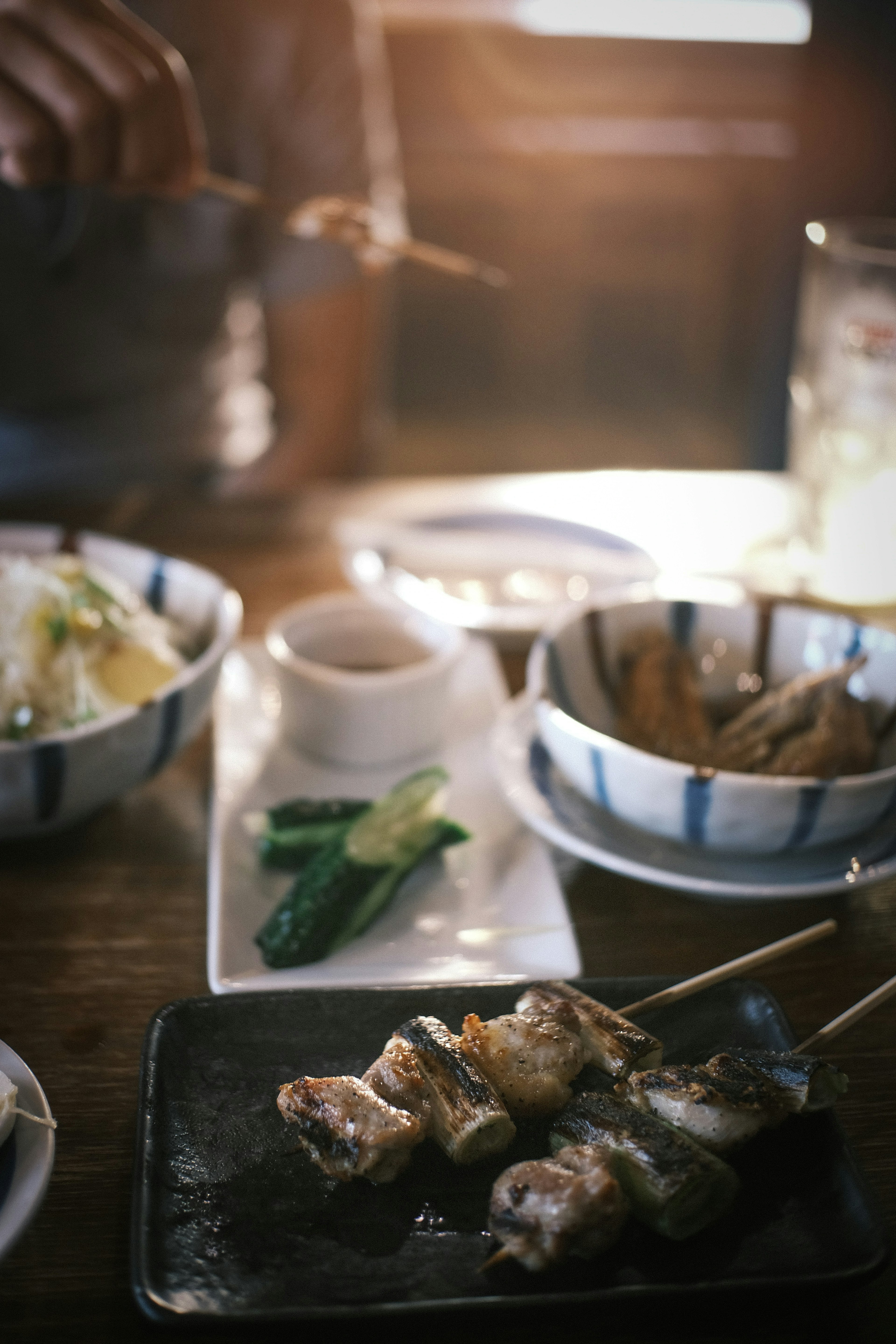 Una mesa con brochetas de pollo a la parrilla y varios acompañamientos