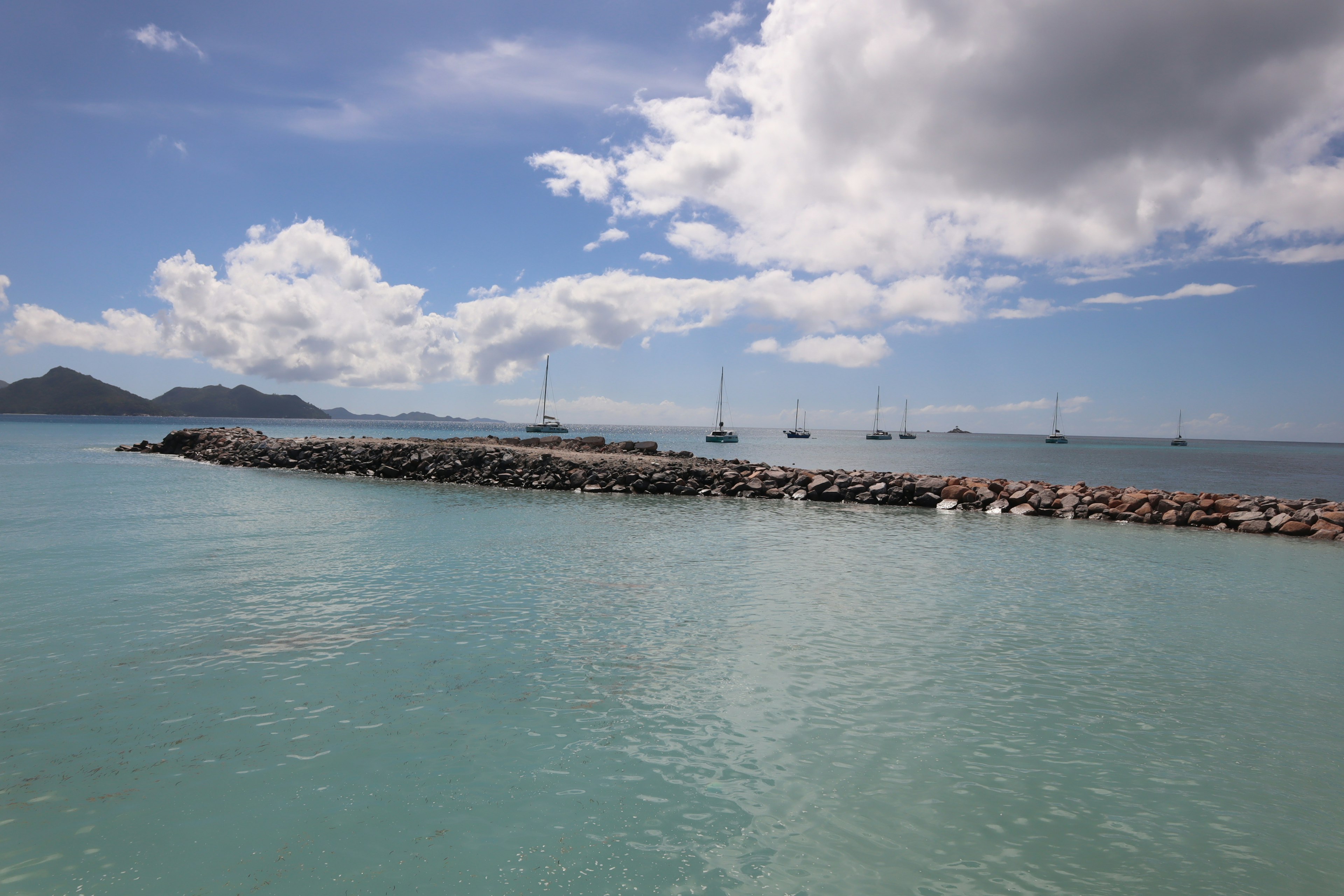 Ruhige Meereslandschaft und blauer Himmel Steindamm, der ins Wasser ragt