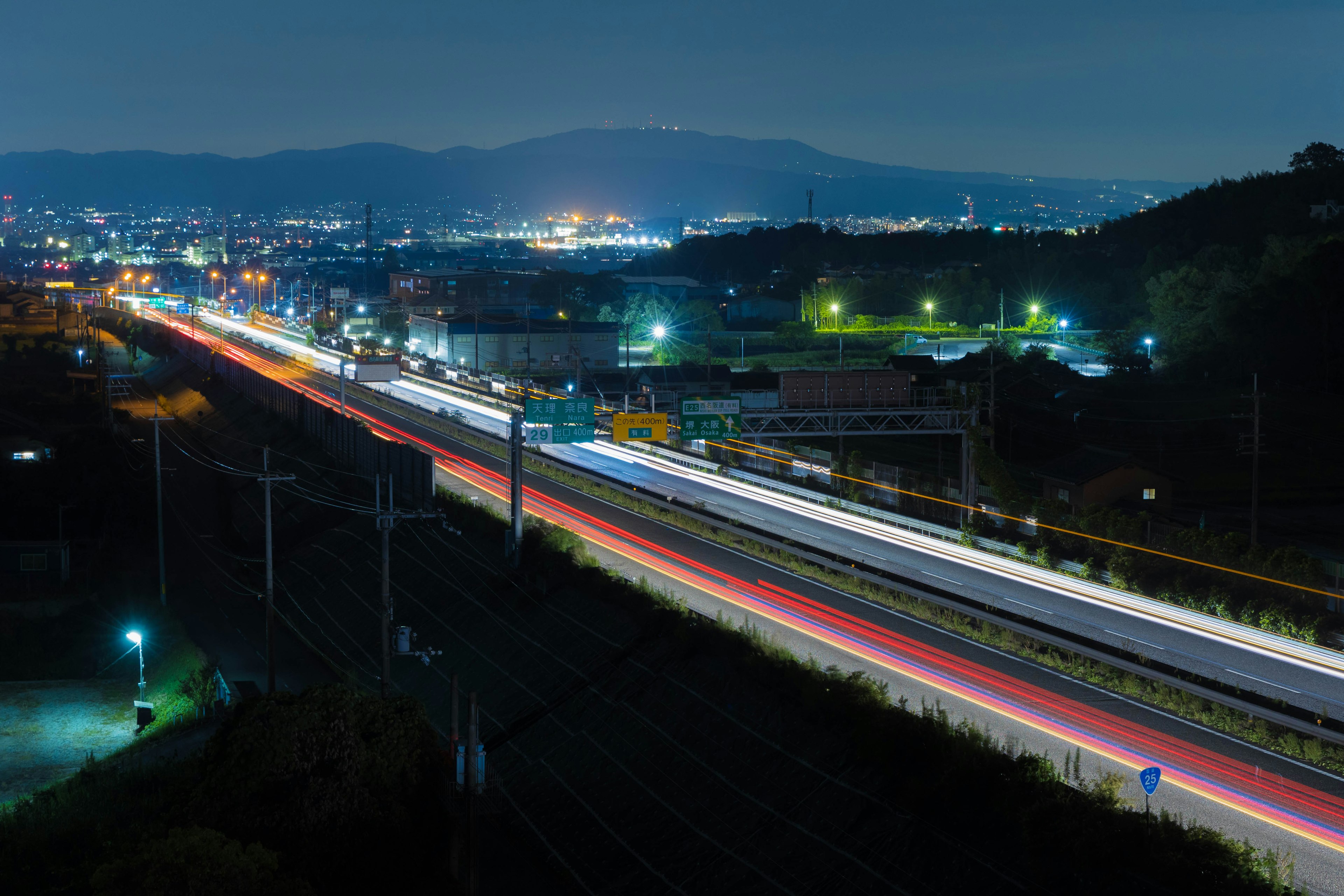 Nachtstraße mit fließendem Verkehr und Stadtlichtern