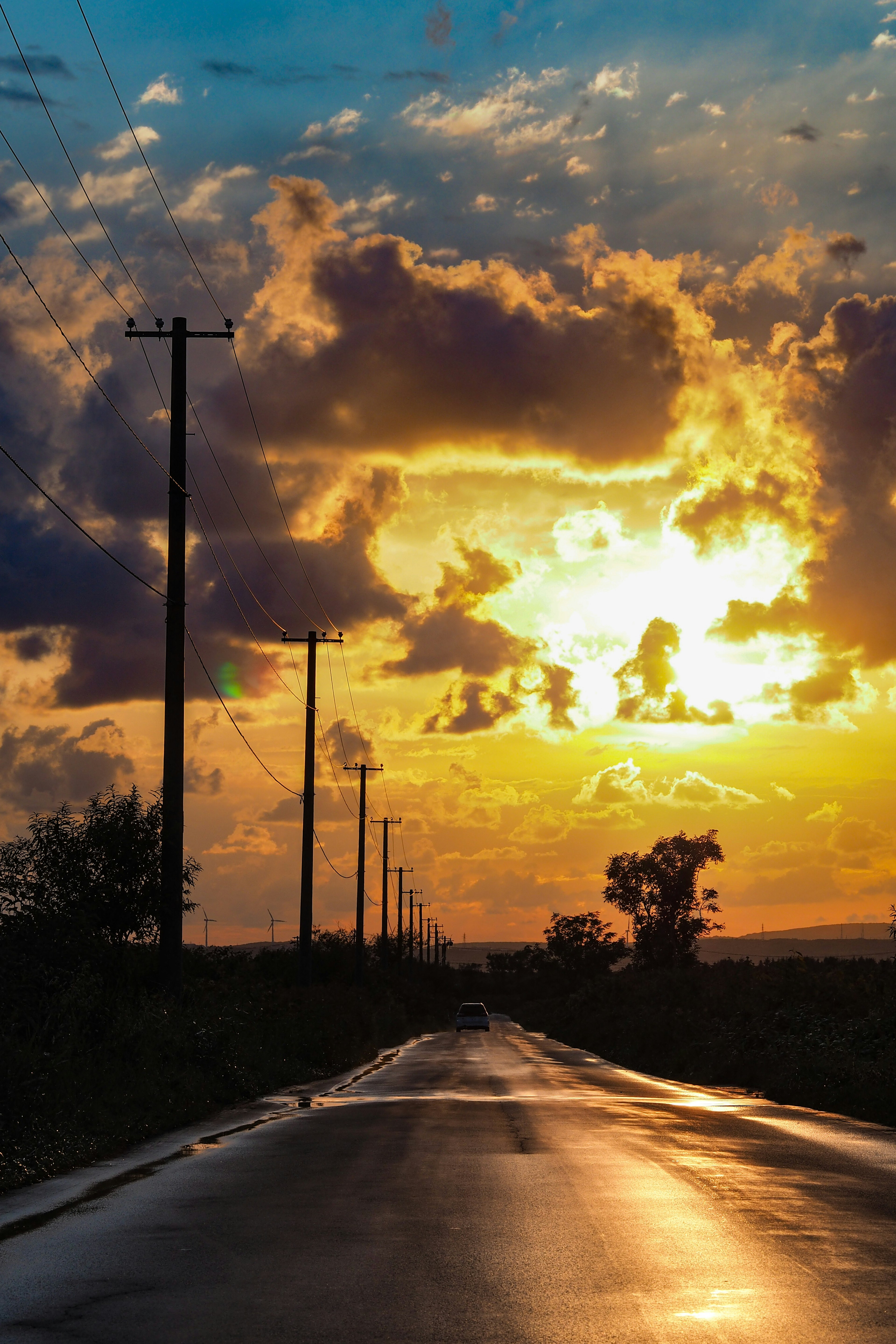 Straße mit Telefonmasten unter einem Himmel bei Sonnenuntergang