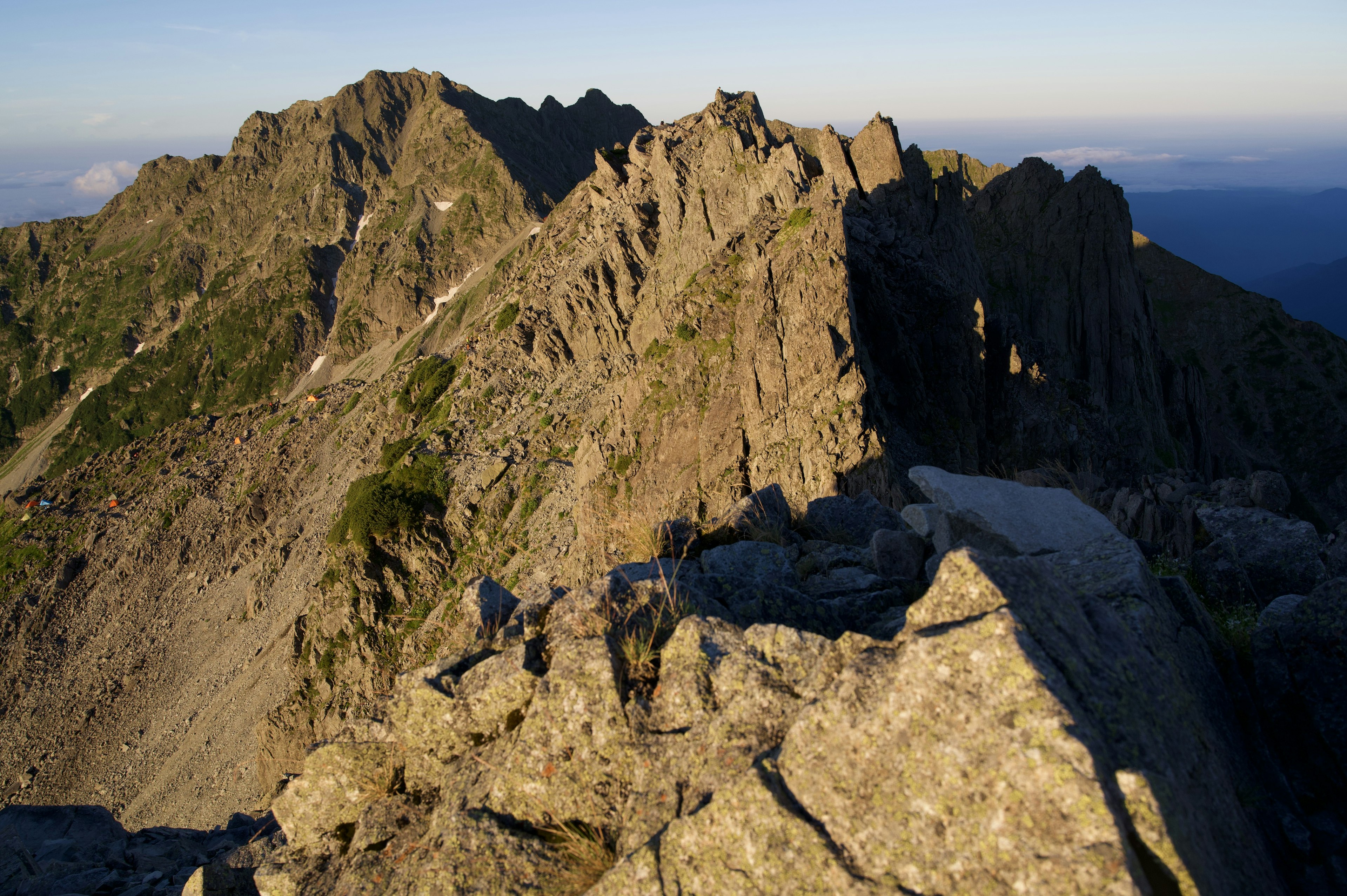 Vista desde la cima de la montaña con picos irregulares y vegetación verde