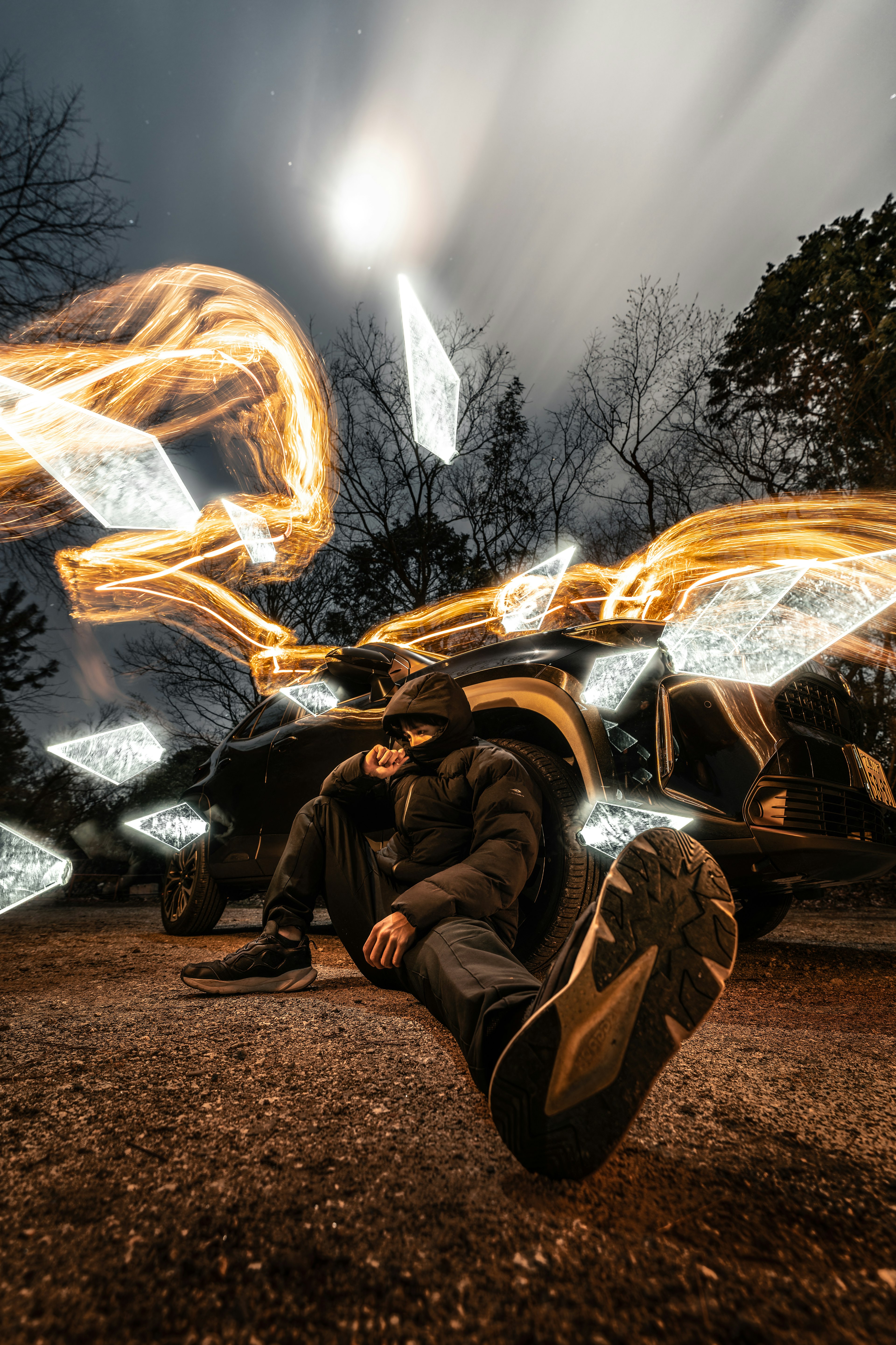 A person sitting on the ground with dramatic light effects surrounding them