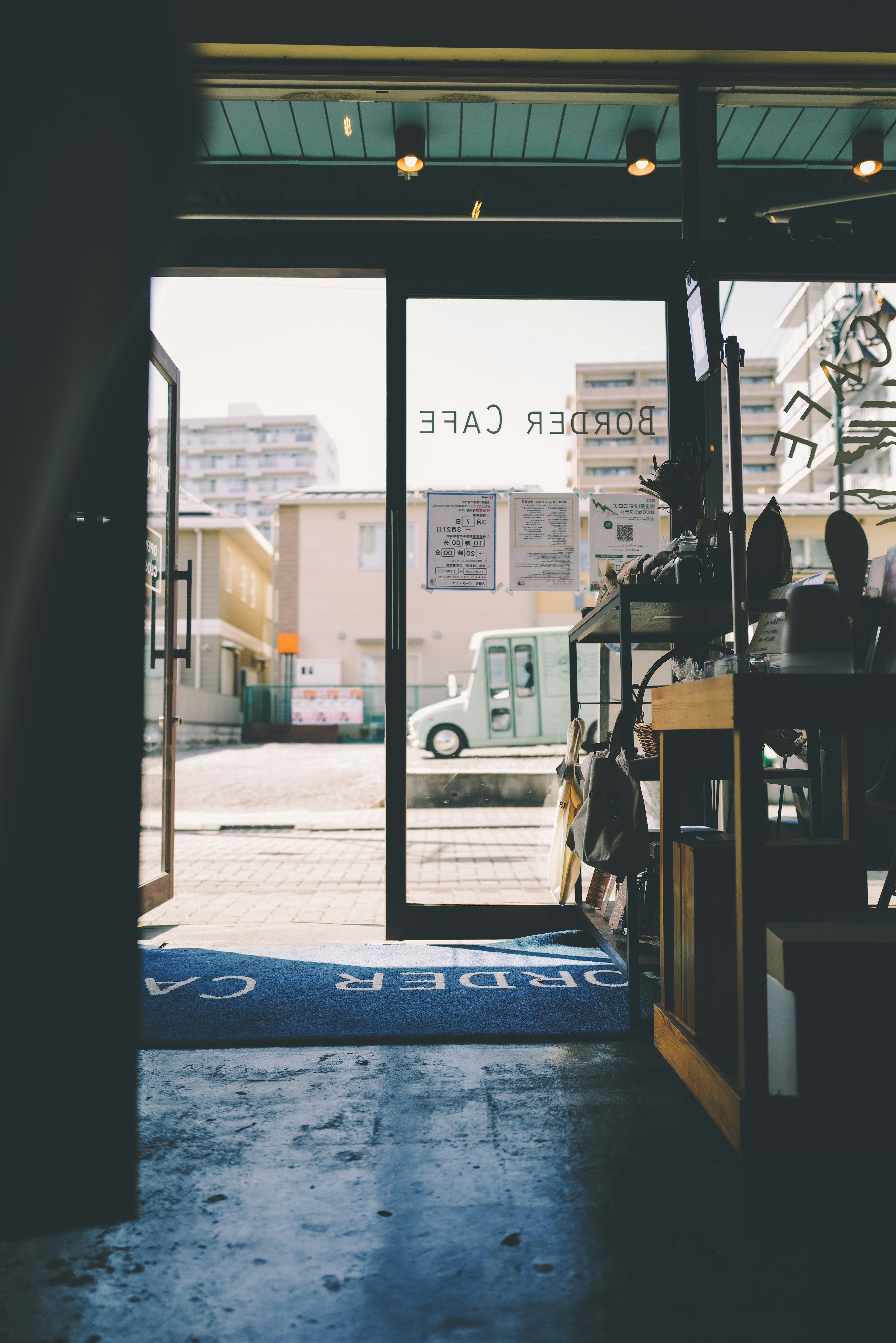 Vista desde dentro de una cafetería mirando hacia afuera a través de la puerta abierta