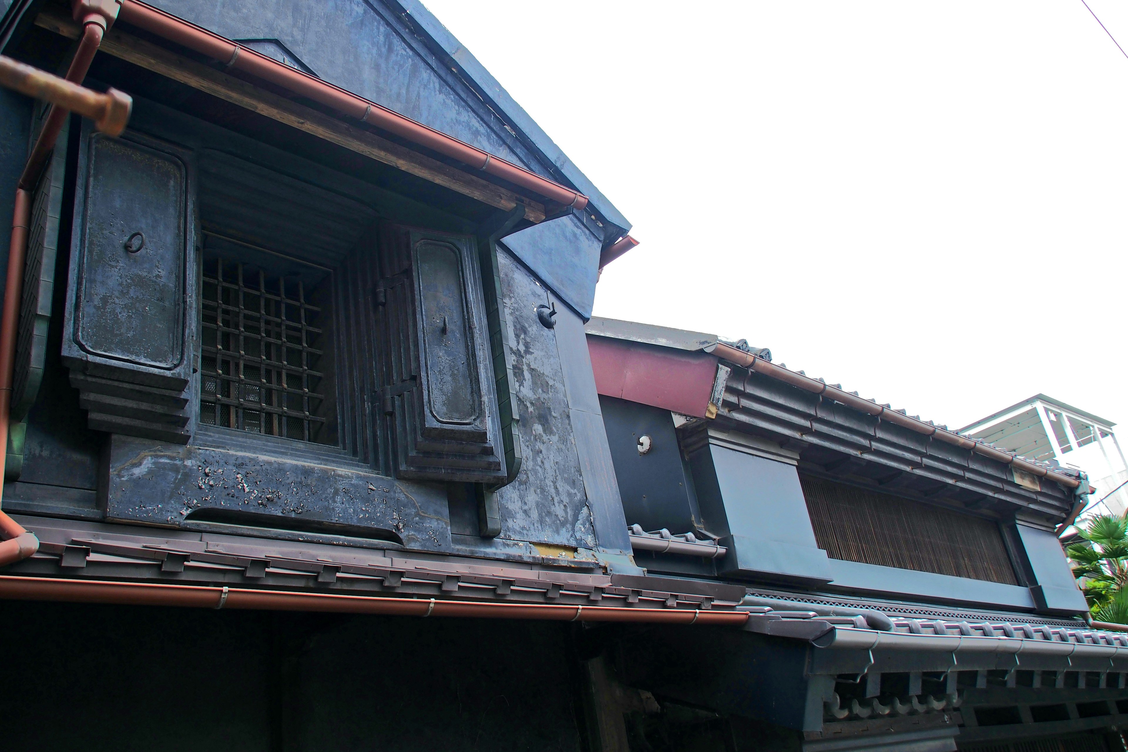 Extérieur d'un bâtiment japonais traditionnel montrant des fenêtres et des détails de toit