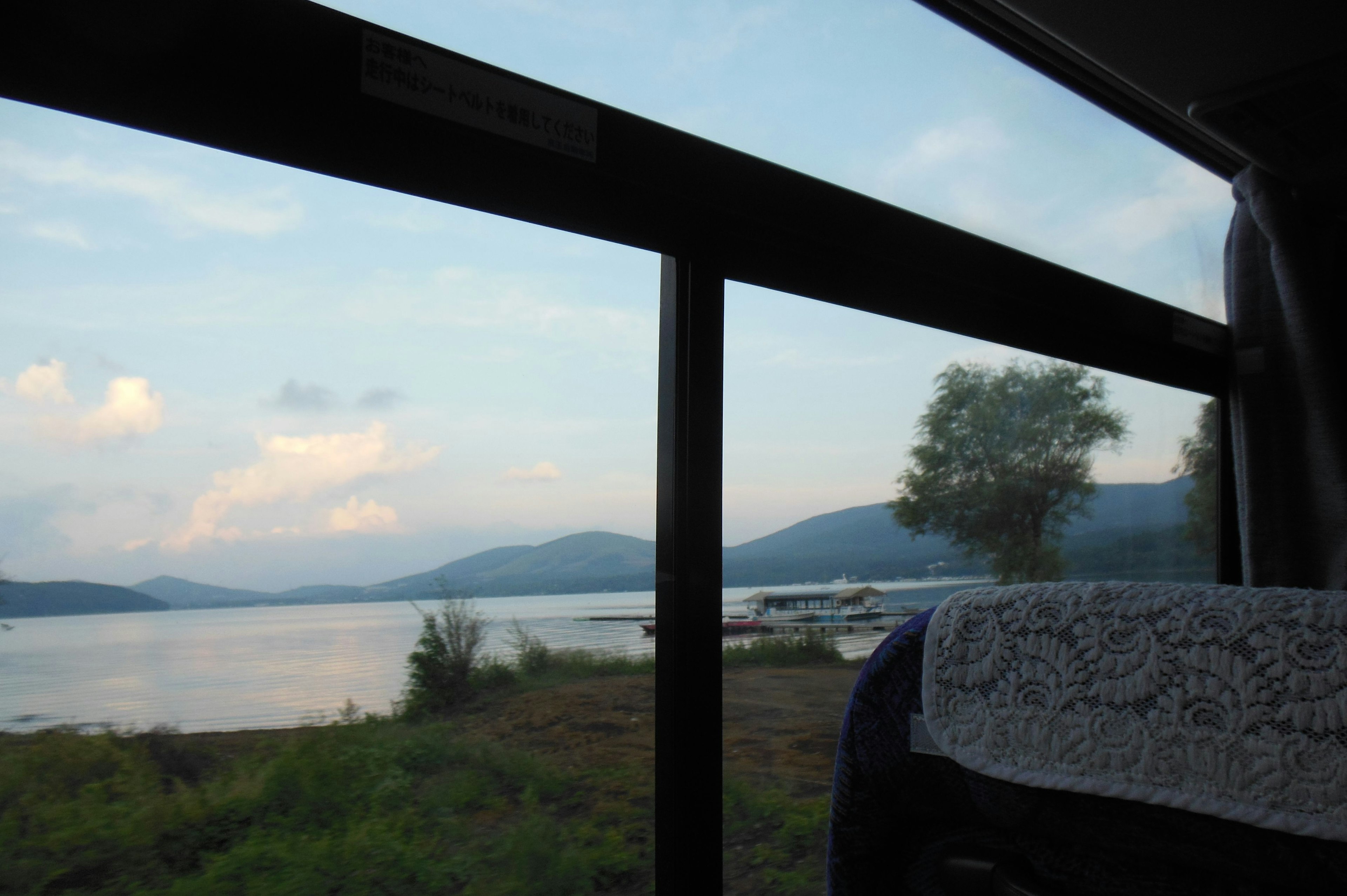 View of a lake and mountains from a bus window