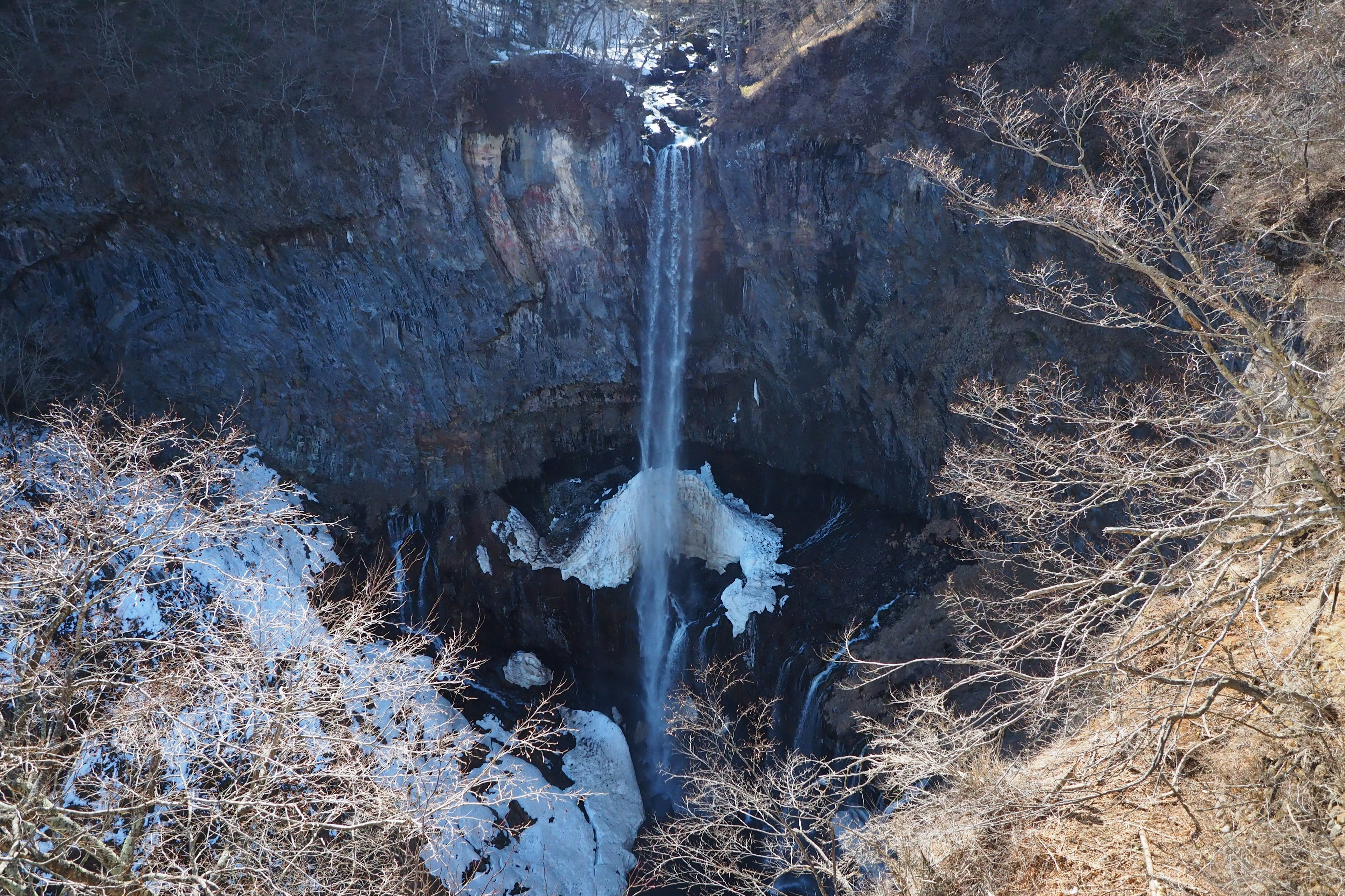 Winter waterfall surrounded by snow-covered rocks