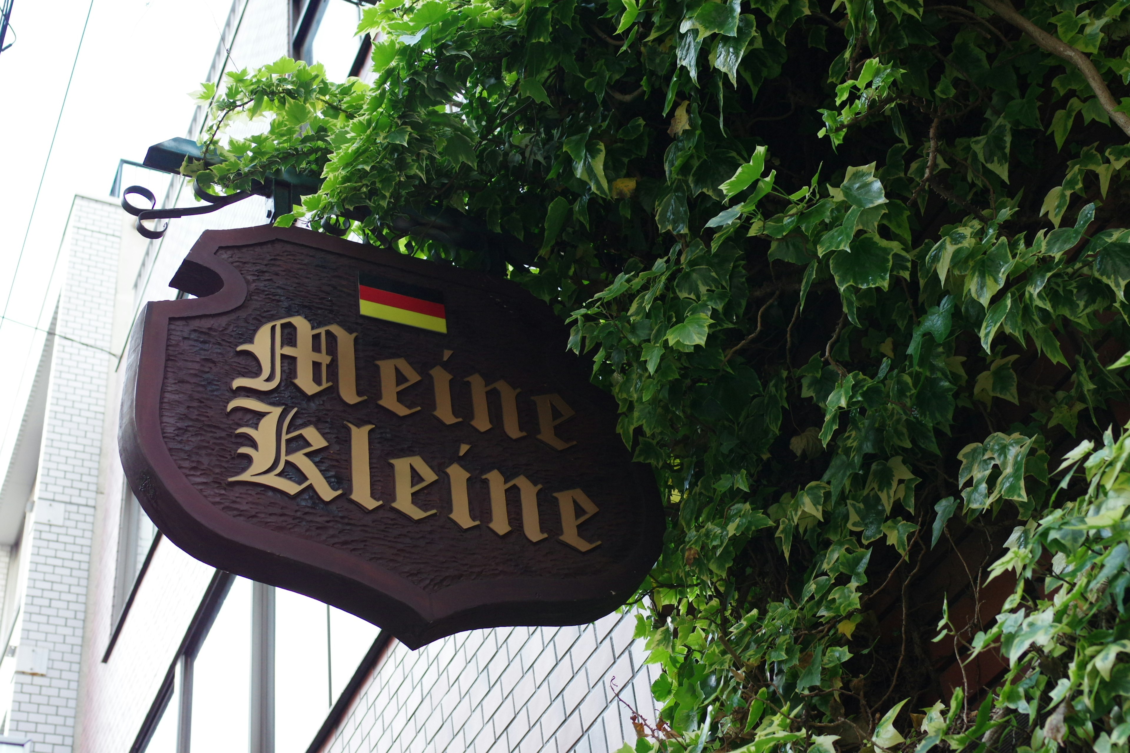 Signboard Meine Kleine surrounded by green leaves