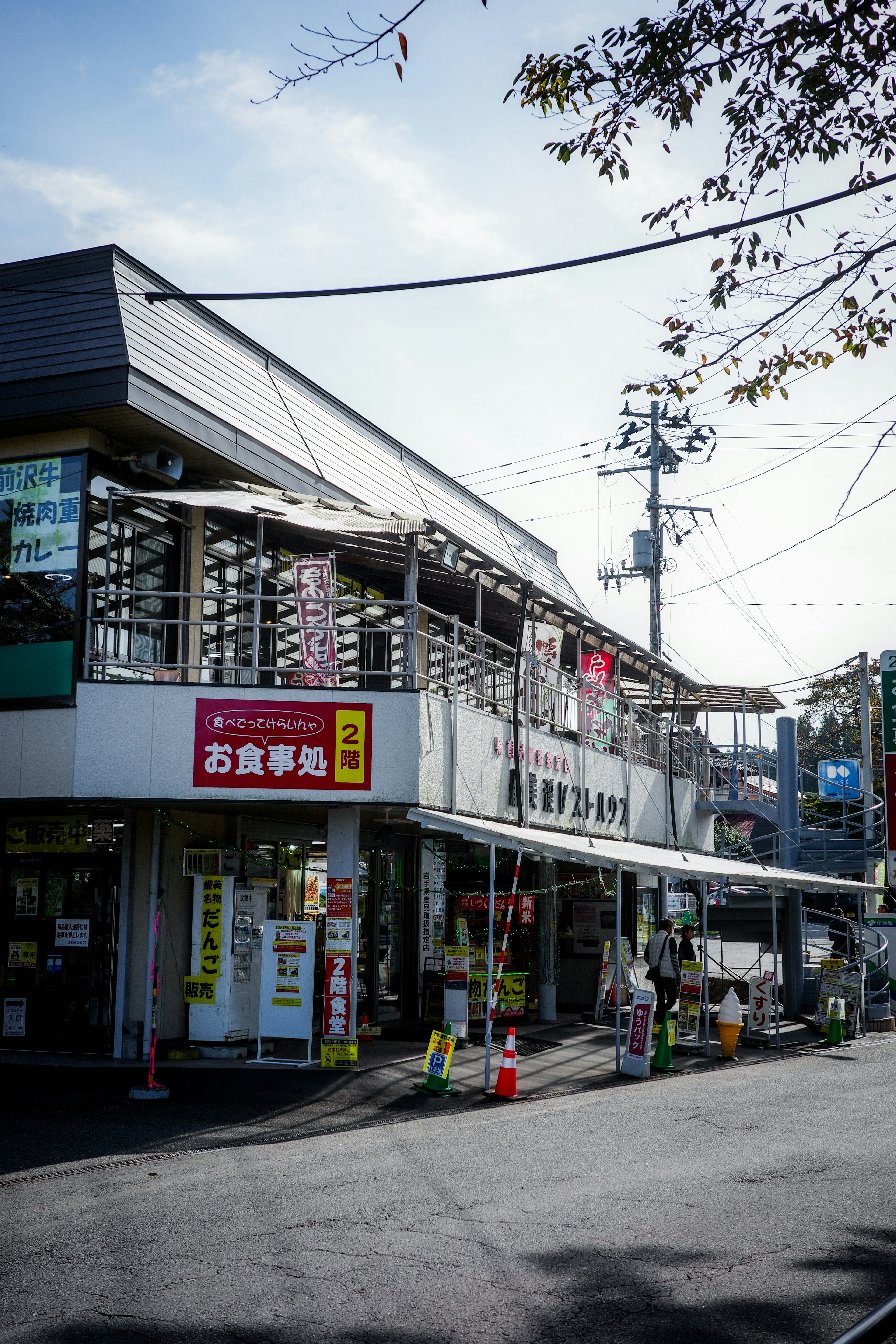 Exterior view of a commercial building with shop signs under a blue sky