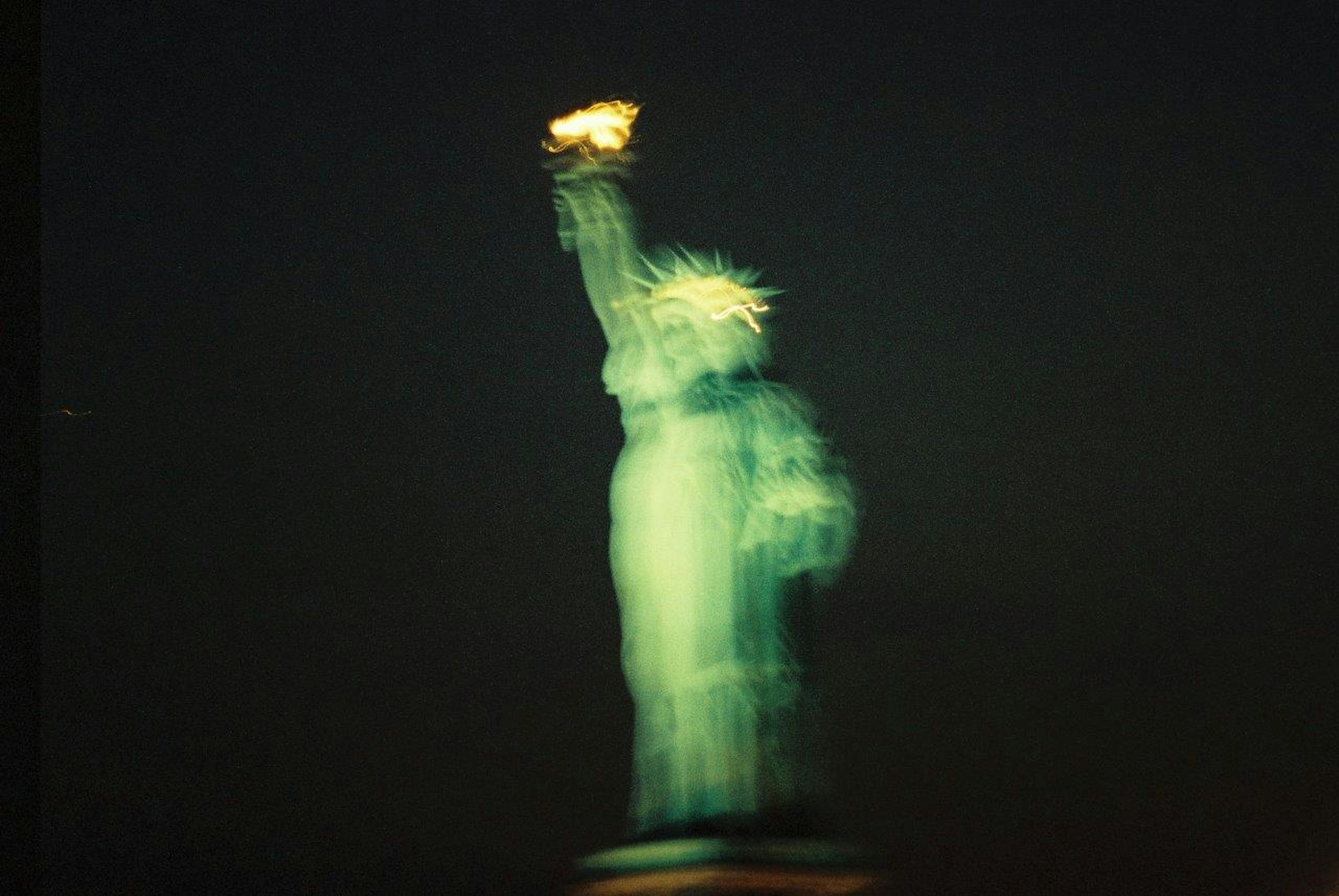 Image floue de la Statue de la Liberté se tenant contre le ciel nocturne