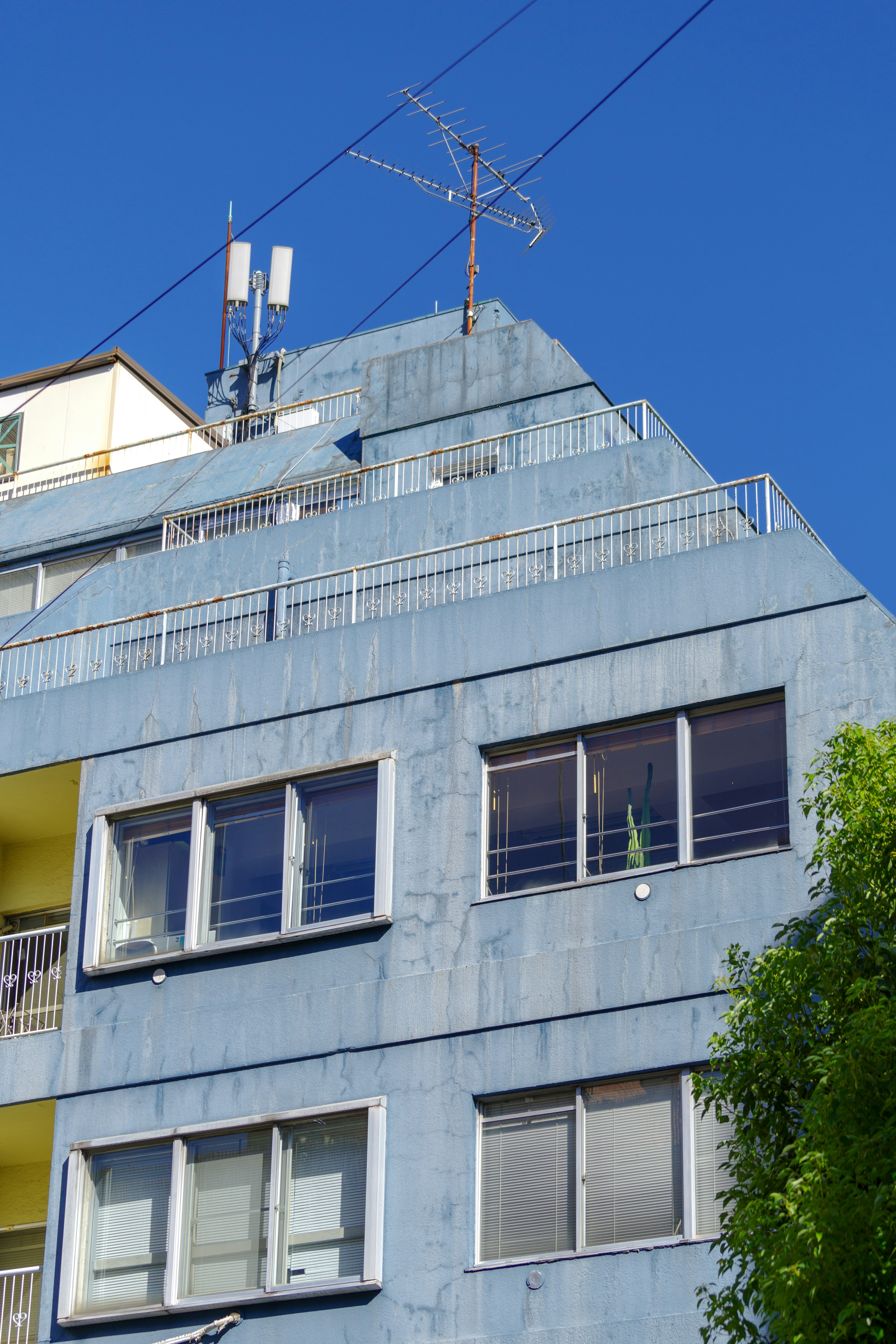 Blue building with antennas and windows on the upper section