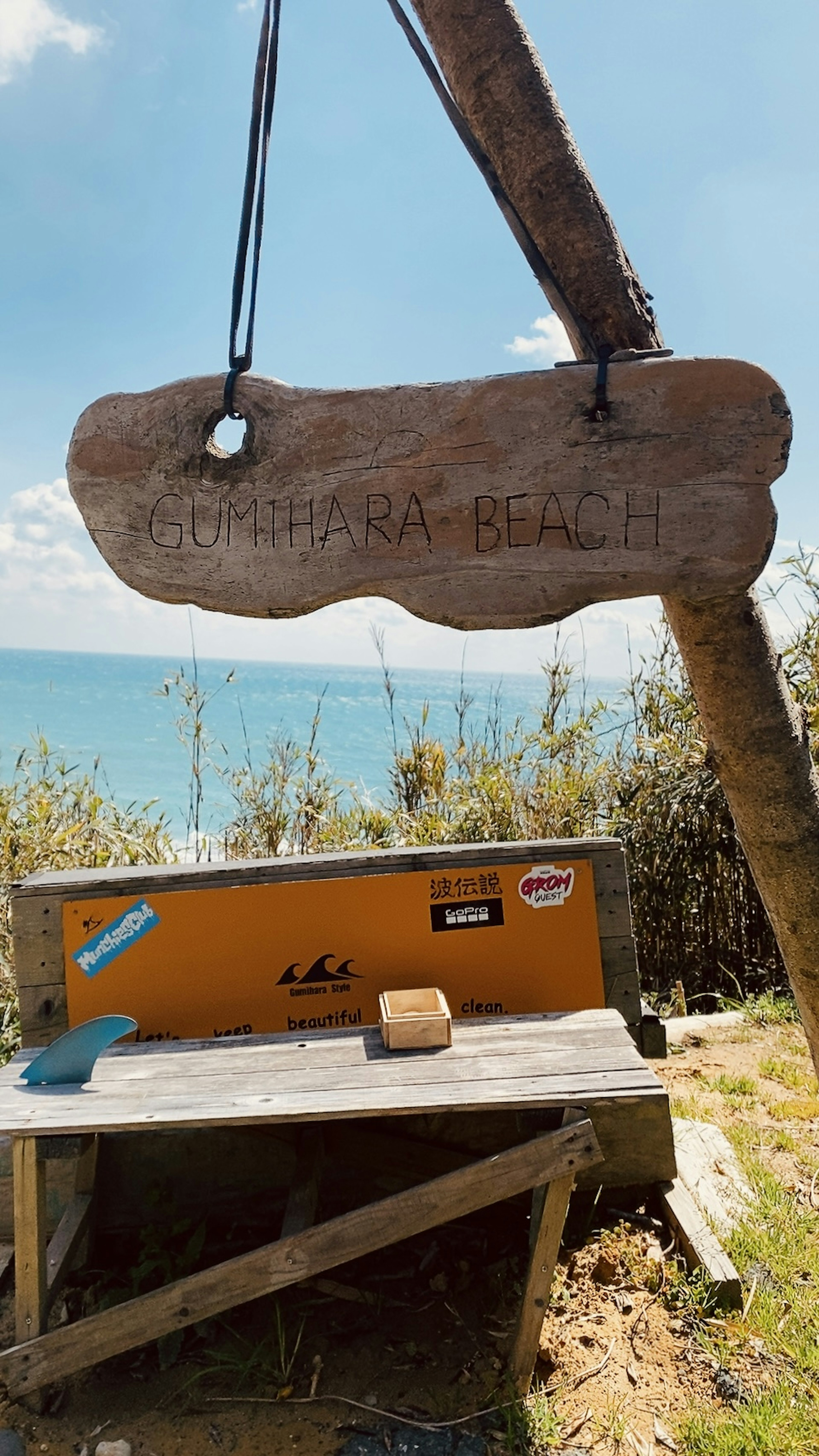 Cartel de madera y mesa con una hermosa vista del océano de fondo