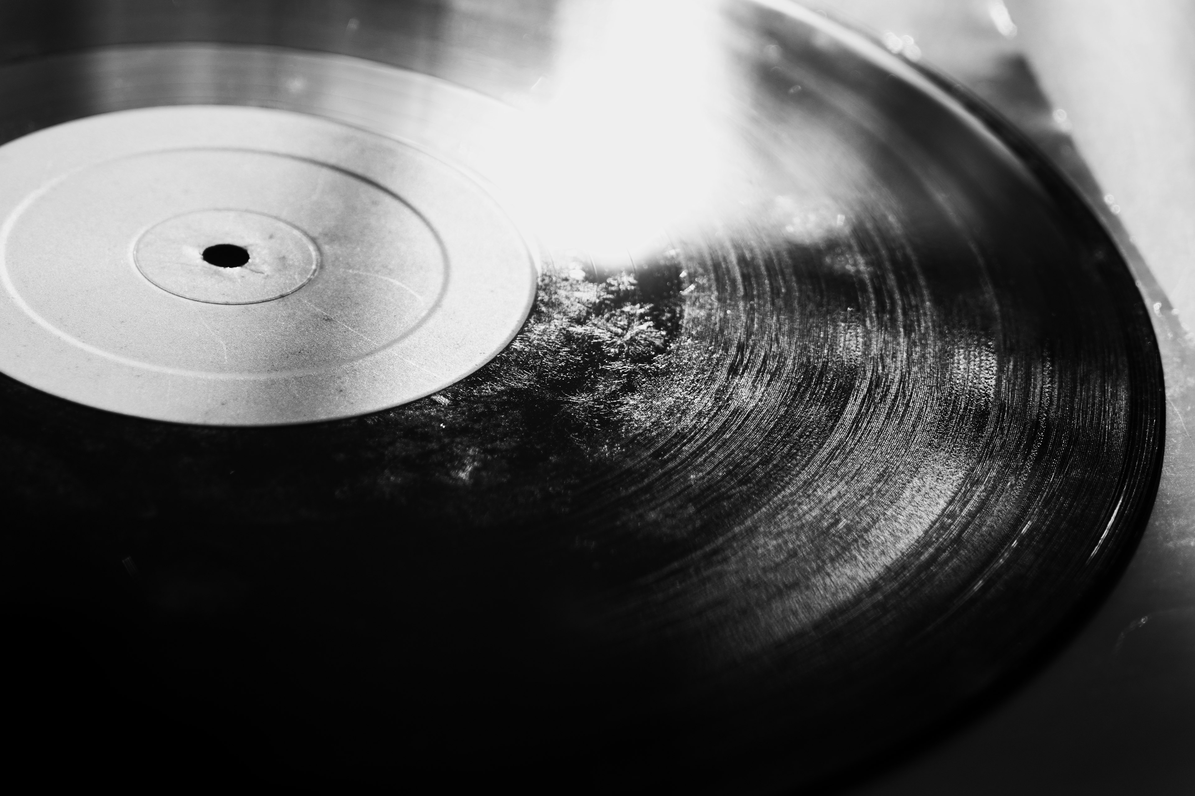 Close-up of a black vinyl record with a glossy surface and a white label