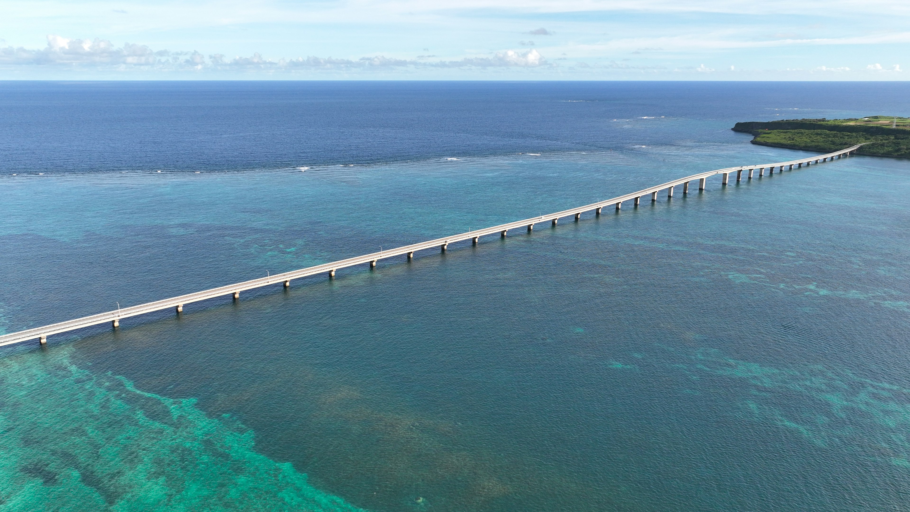 Vista aérea de un largo puente sobre el agua azul del océano