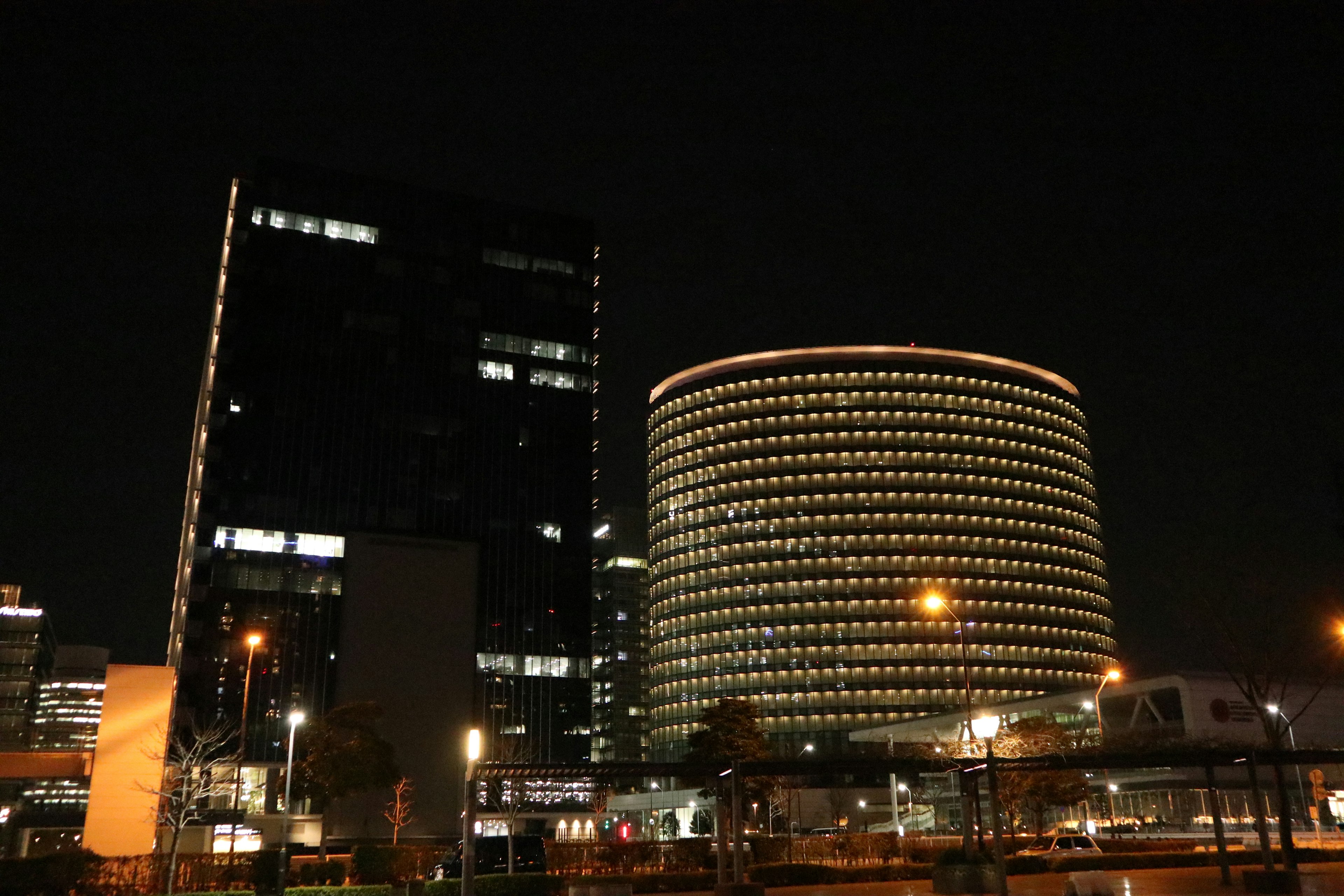 Night cityscape featuring skyscrapers and a round building