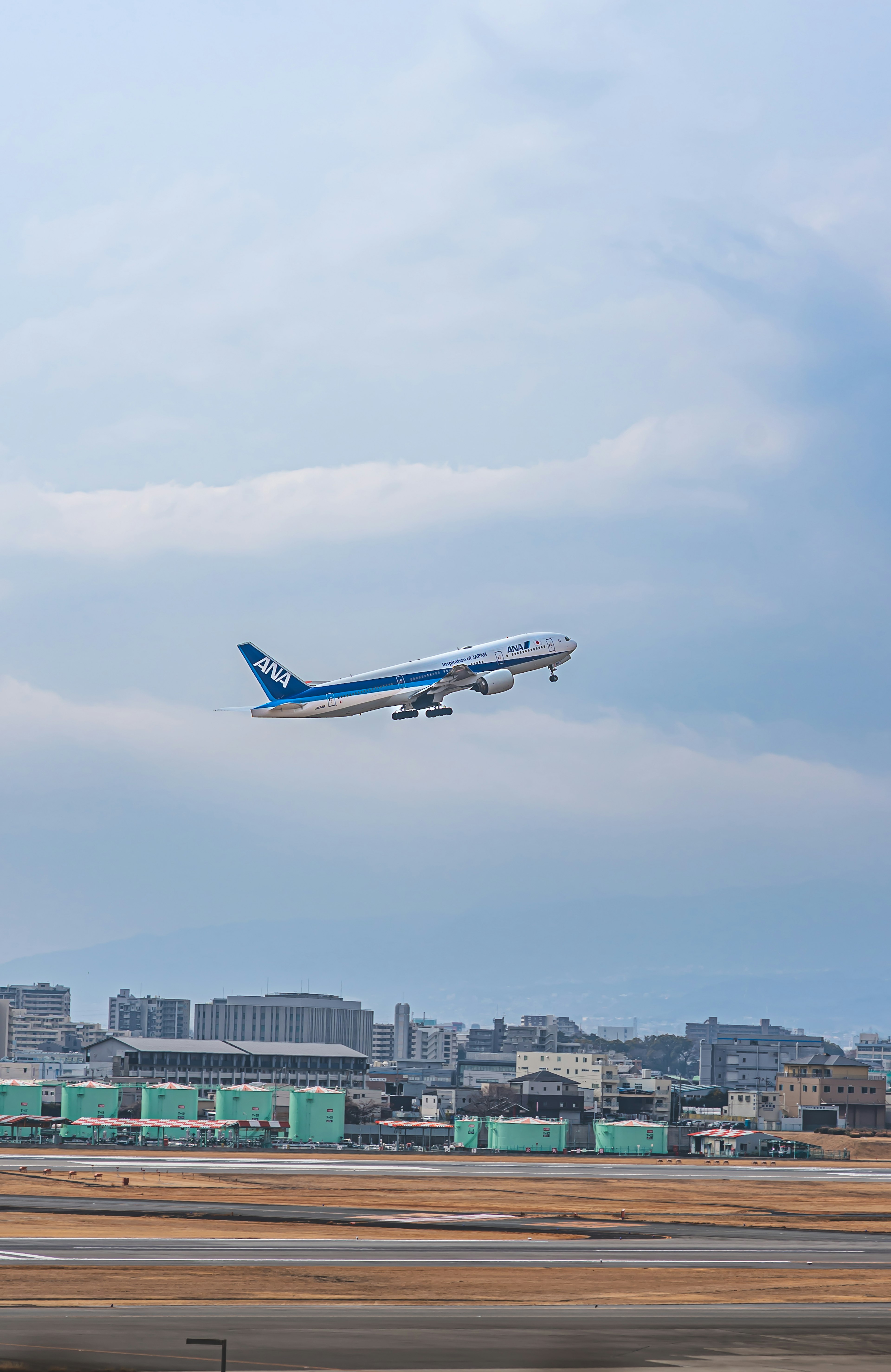 Airplane taking off with city skyline in background