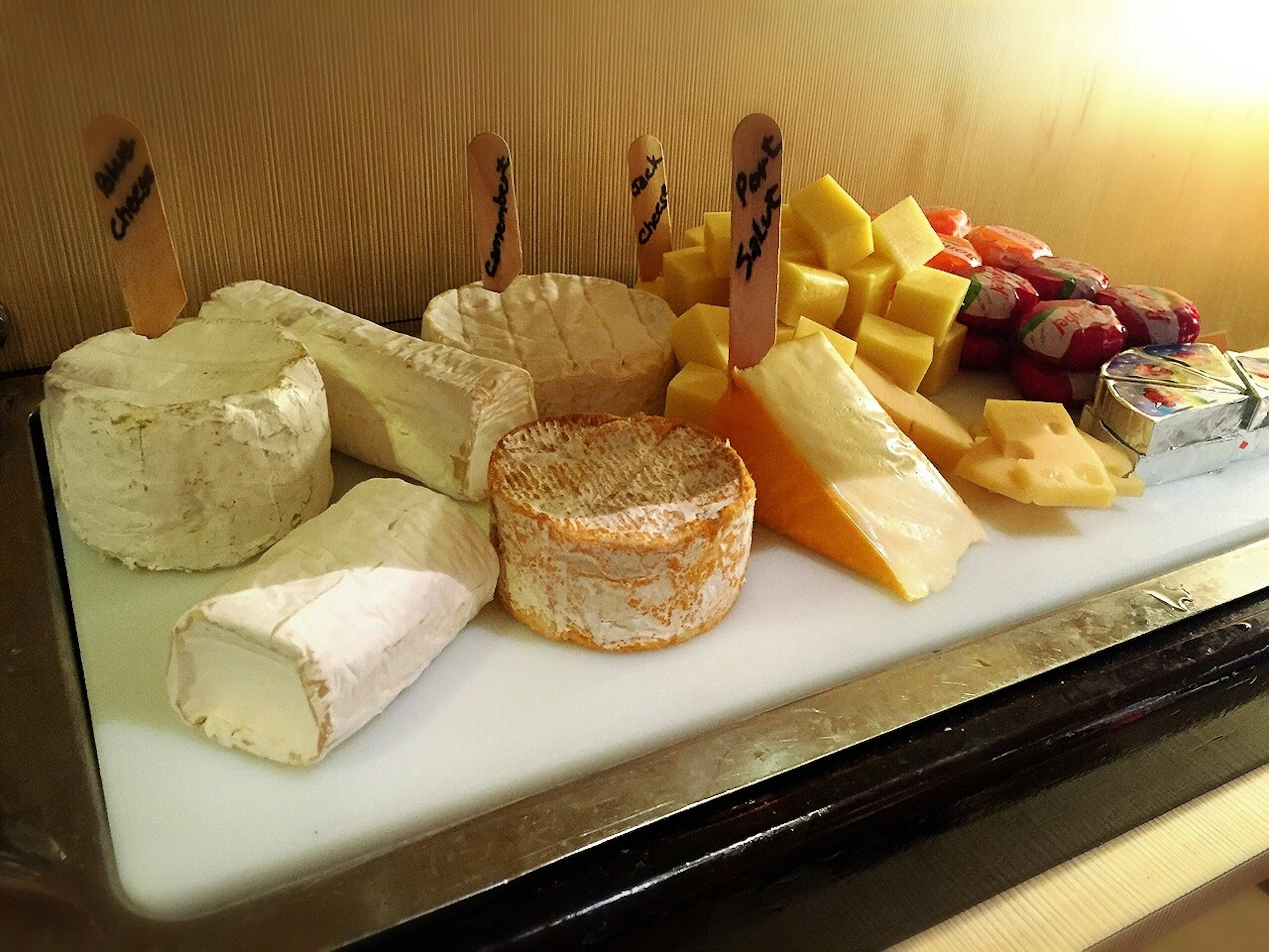 A selection of various cheeses and fruits displayed on a platter