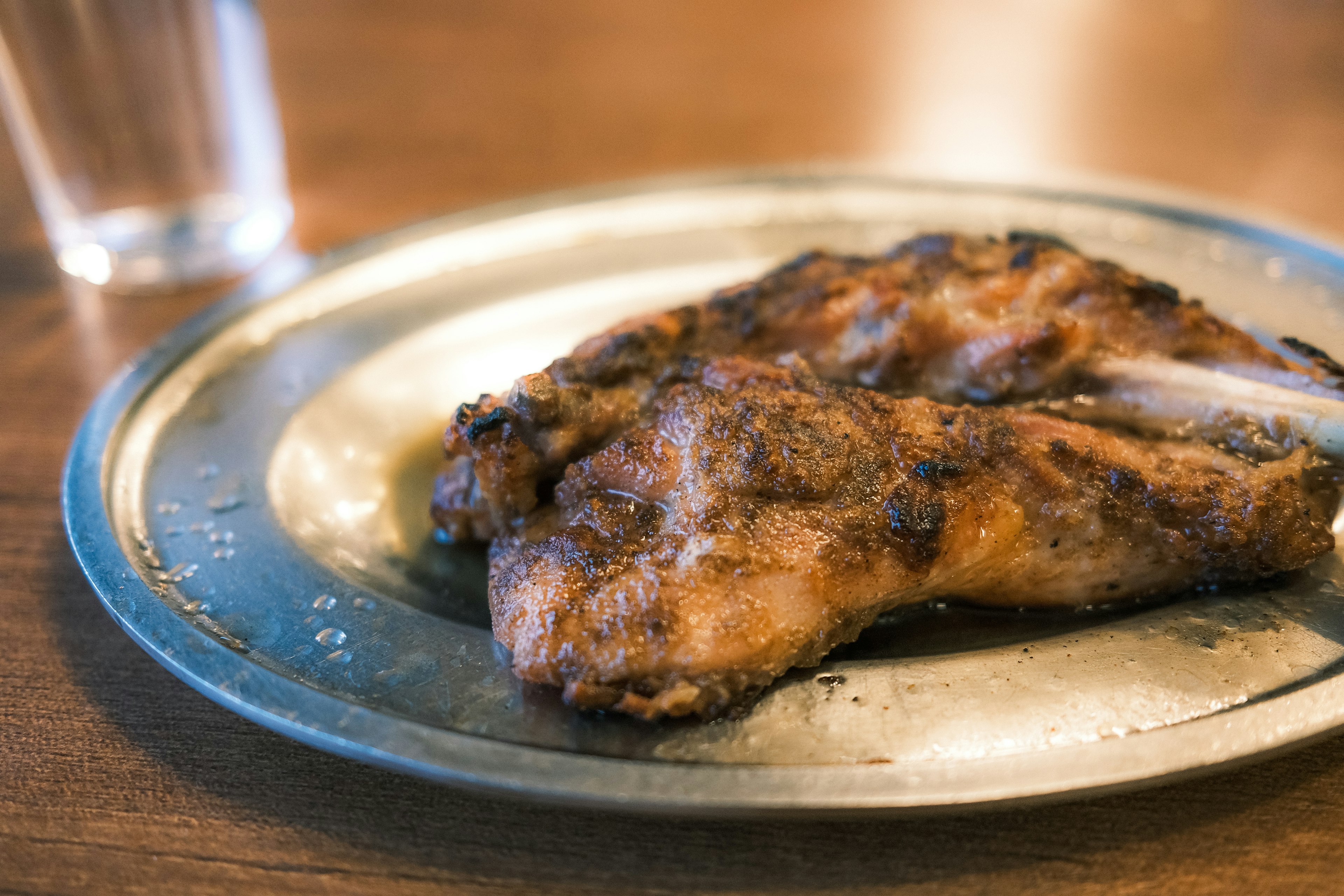 Cuisse de poulet grillée servie sur une assiette en métal