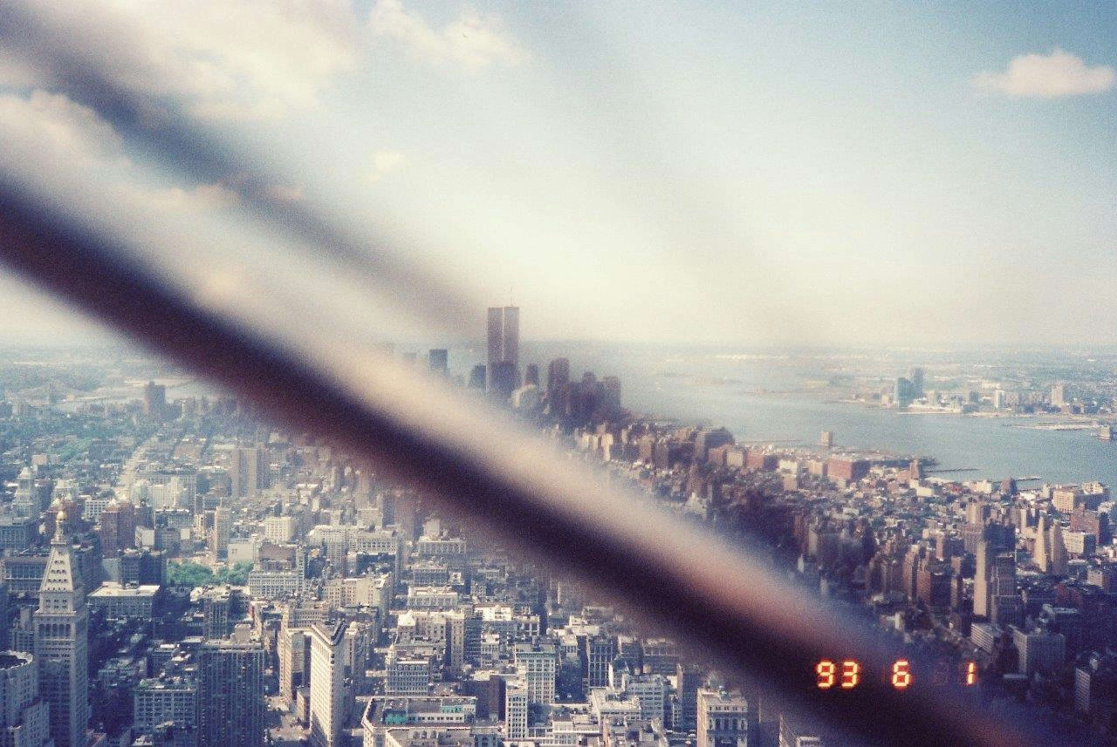 Verschwommene Fotografie der Skyline von New York mit einem Metallstab im Vordergrund