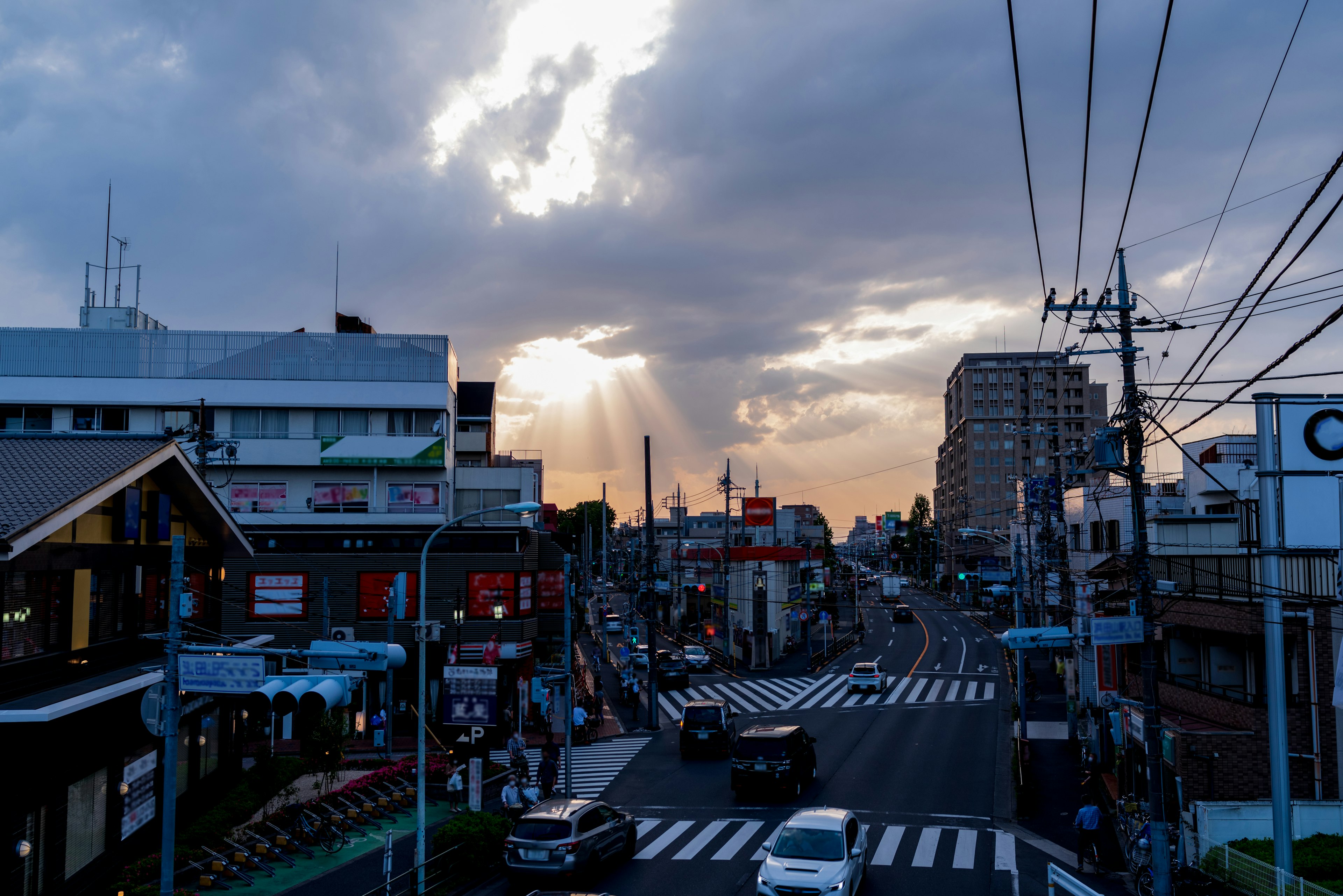 Paisaje urbano mostrando un atardecer con nubes y rayos de luz