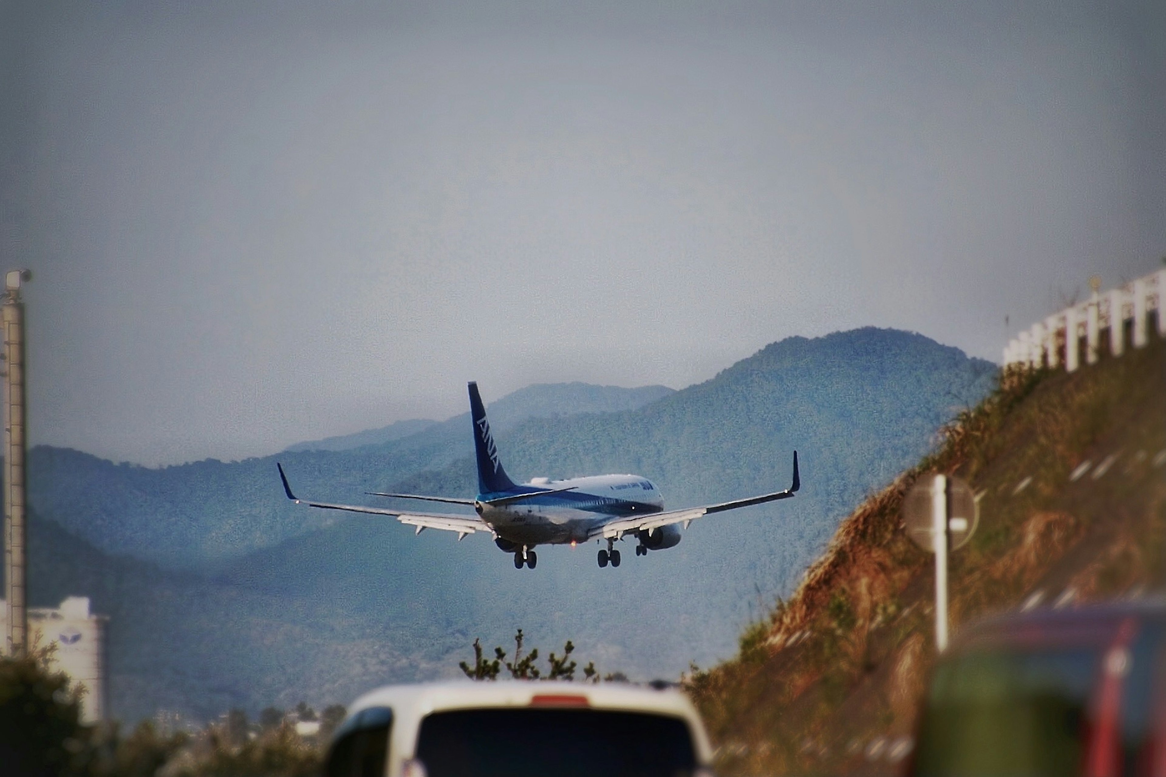 飛機在機場降落，背景是山脈