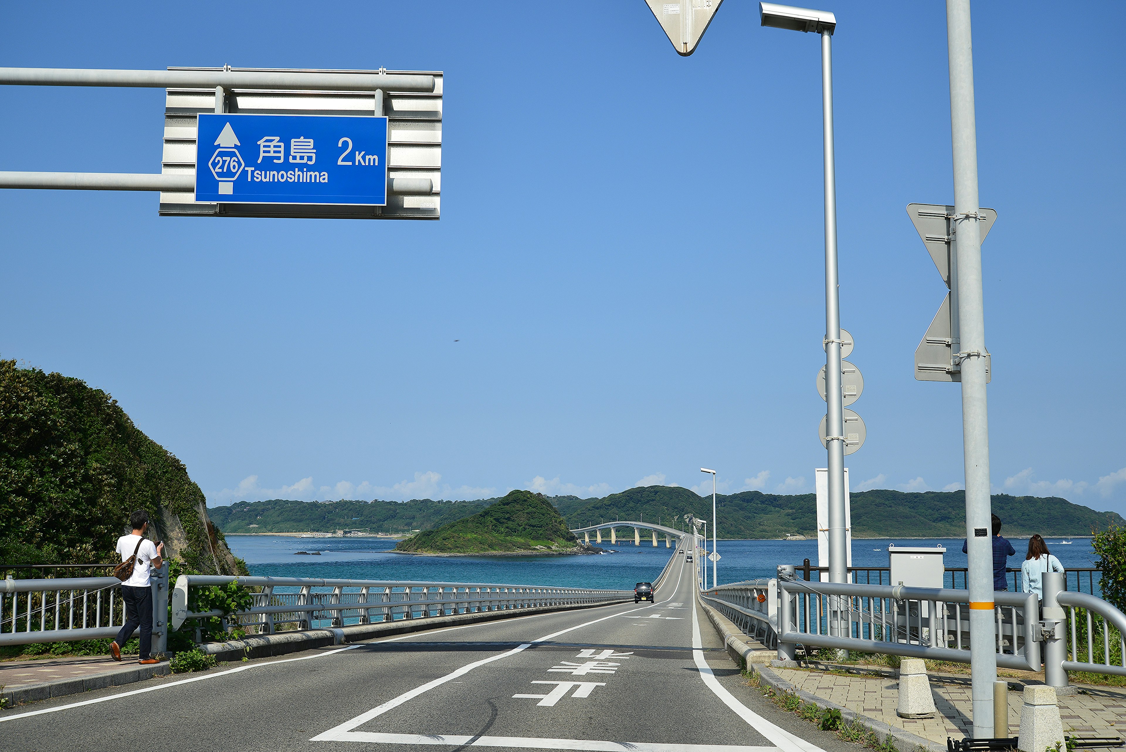 Verkehrsschild mit Blick auf das blaue Meer und die Brücke im Hintergrund