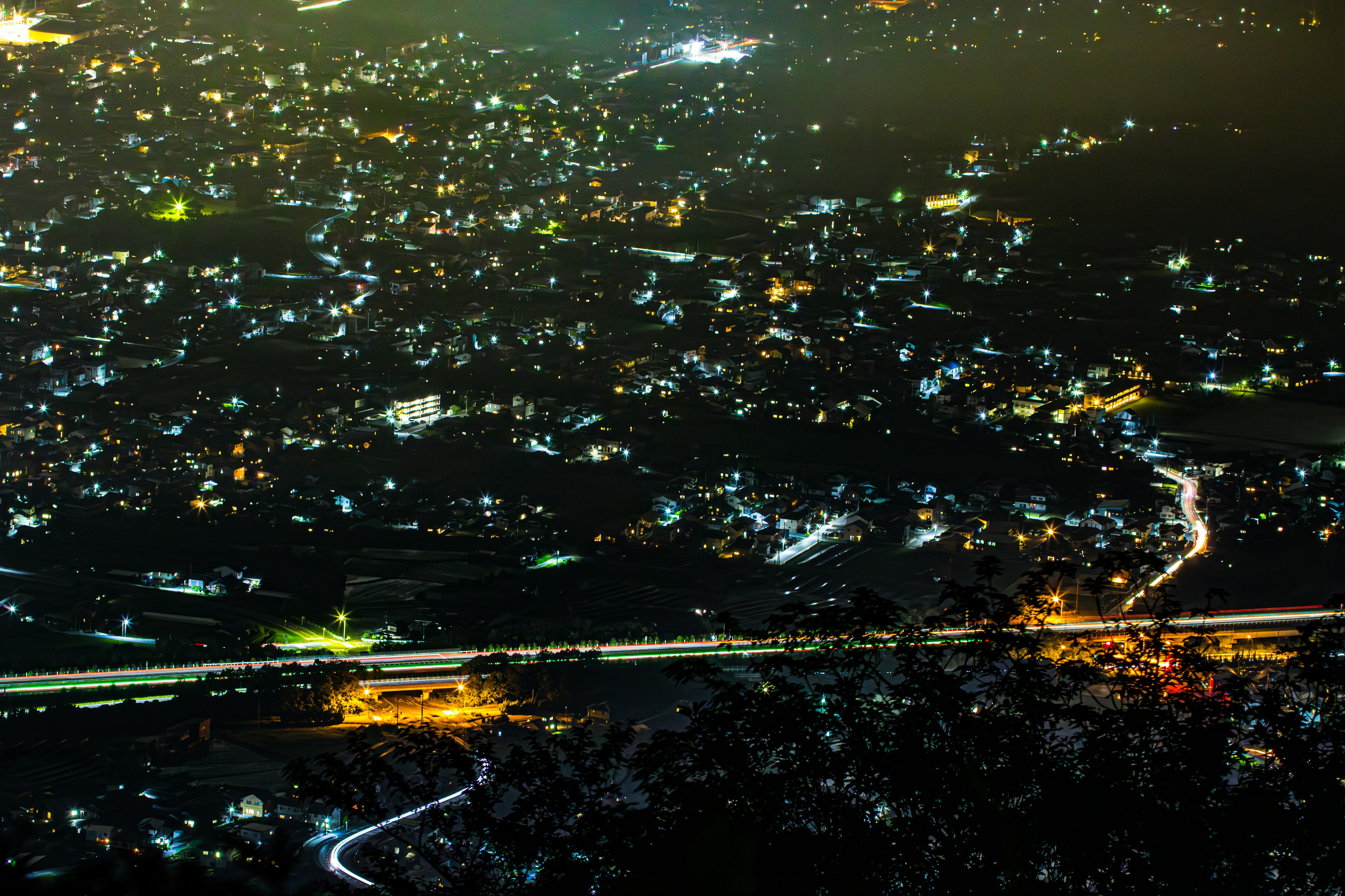 Paesaggio urbano notturno con luci scintillanti lungo l'autostrada