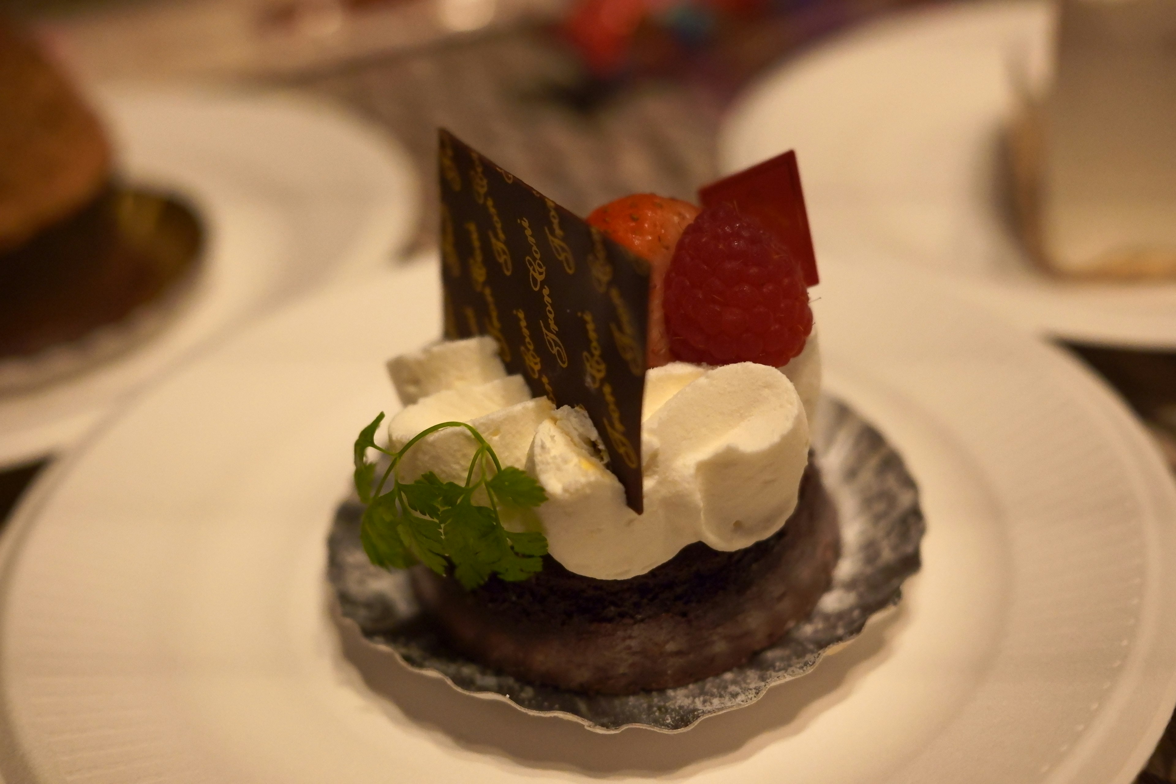 Gâteau au chocolat surmonté de crème fouettée et d'éléments décoratifs sur une assiette de dessert