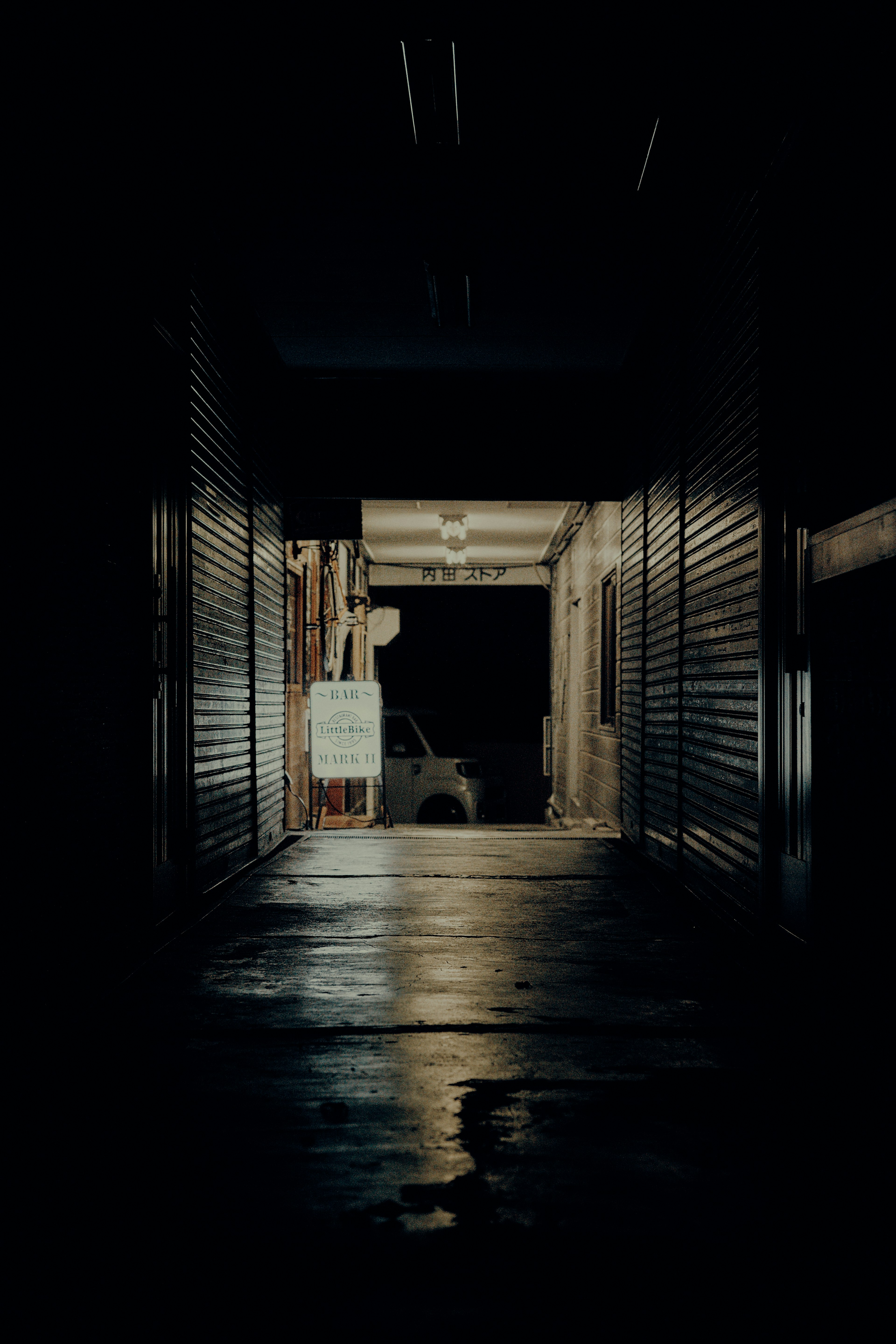 Dark corridor leading to a lighted exit