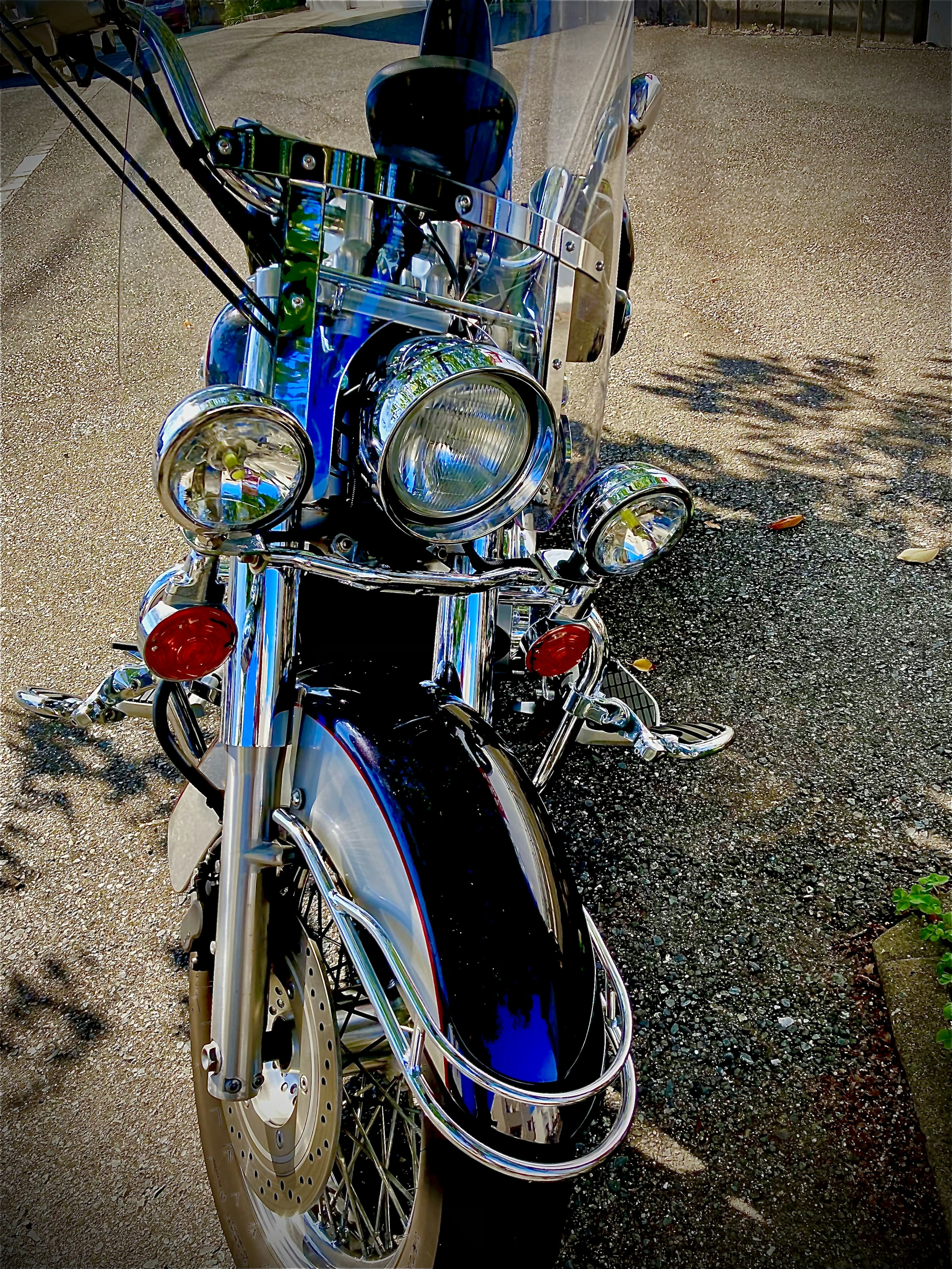 Tampilan depan sepeda motor biru dengan lampu depan krom dan desain bergaya