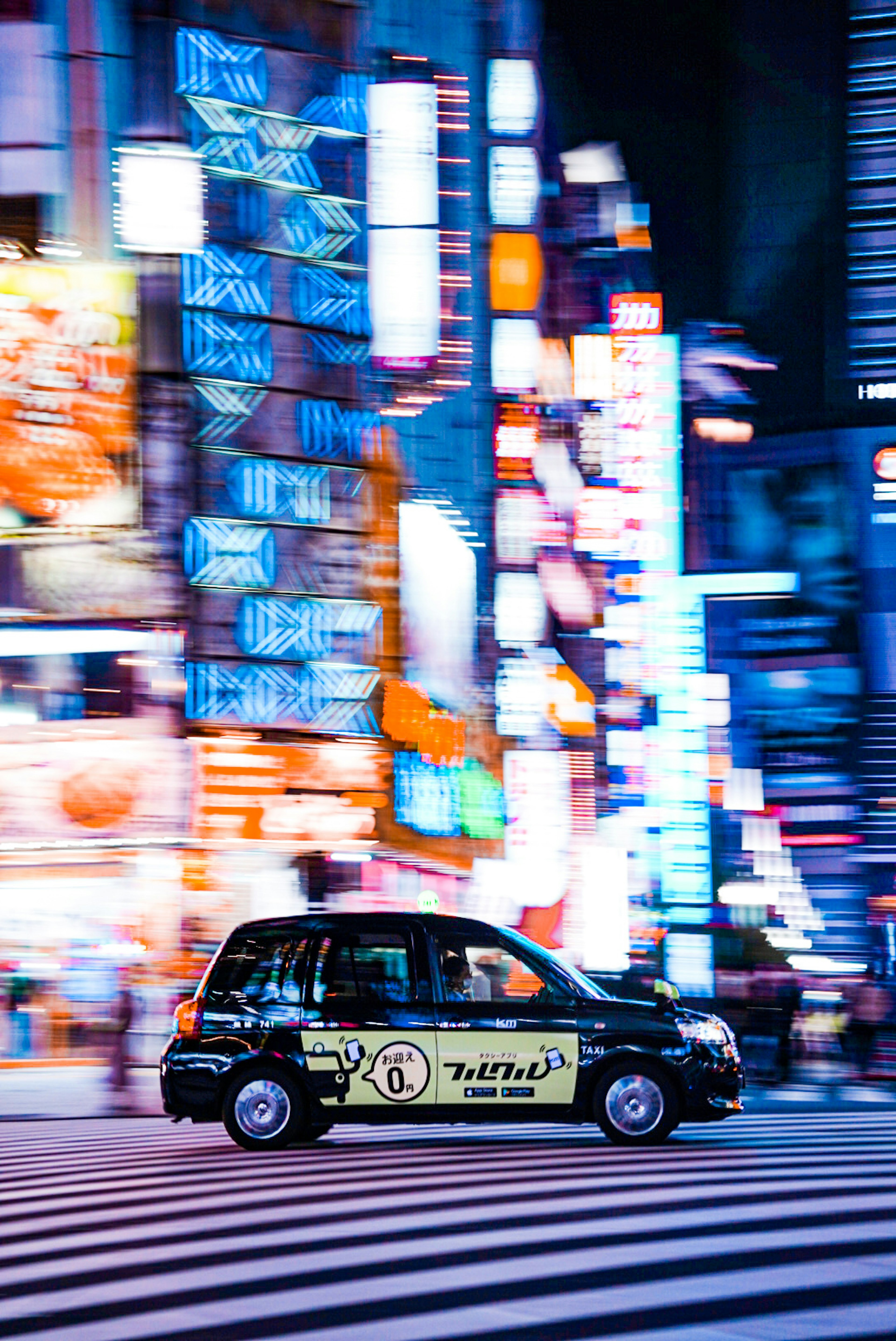 Taxi driving through a vibrant Tokyo street illuminated by neon lights