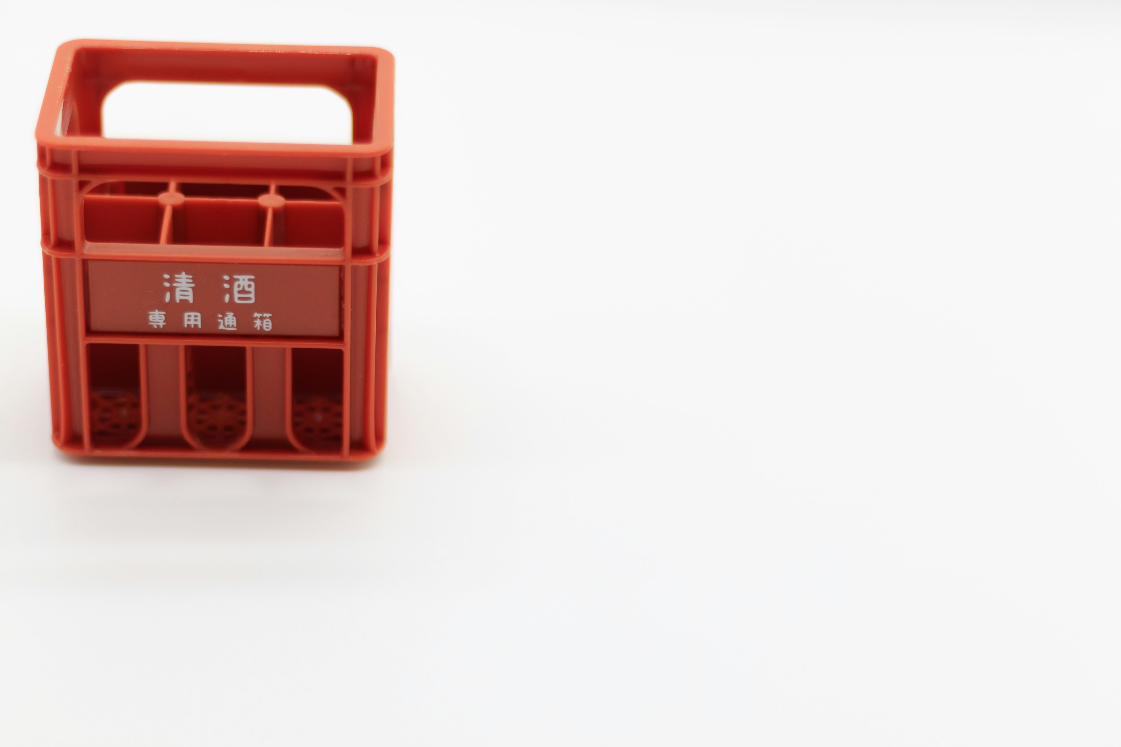 Red plastic storage crate placed on a white background