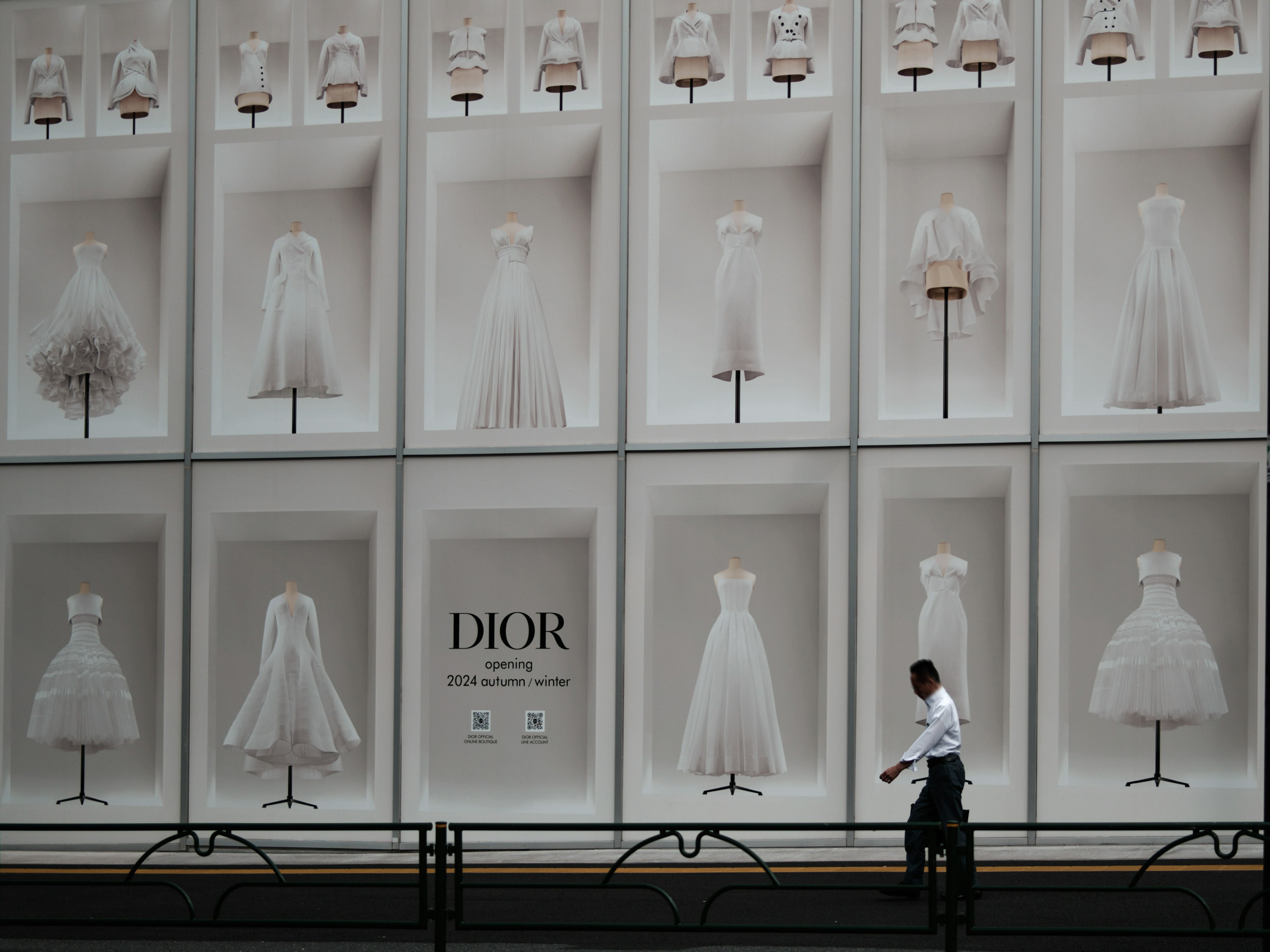 Vitrina con vestidos blancos de Dior y un transeúnte