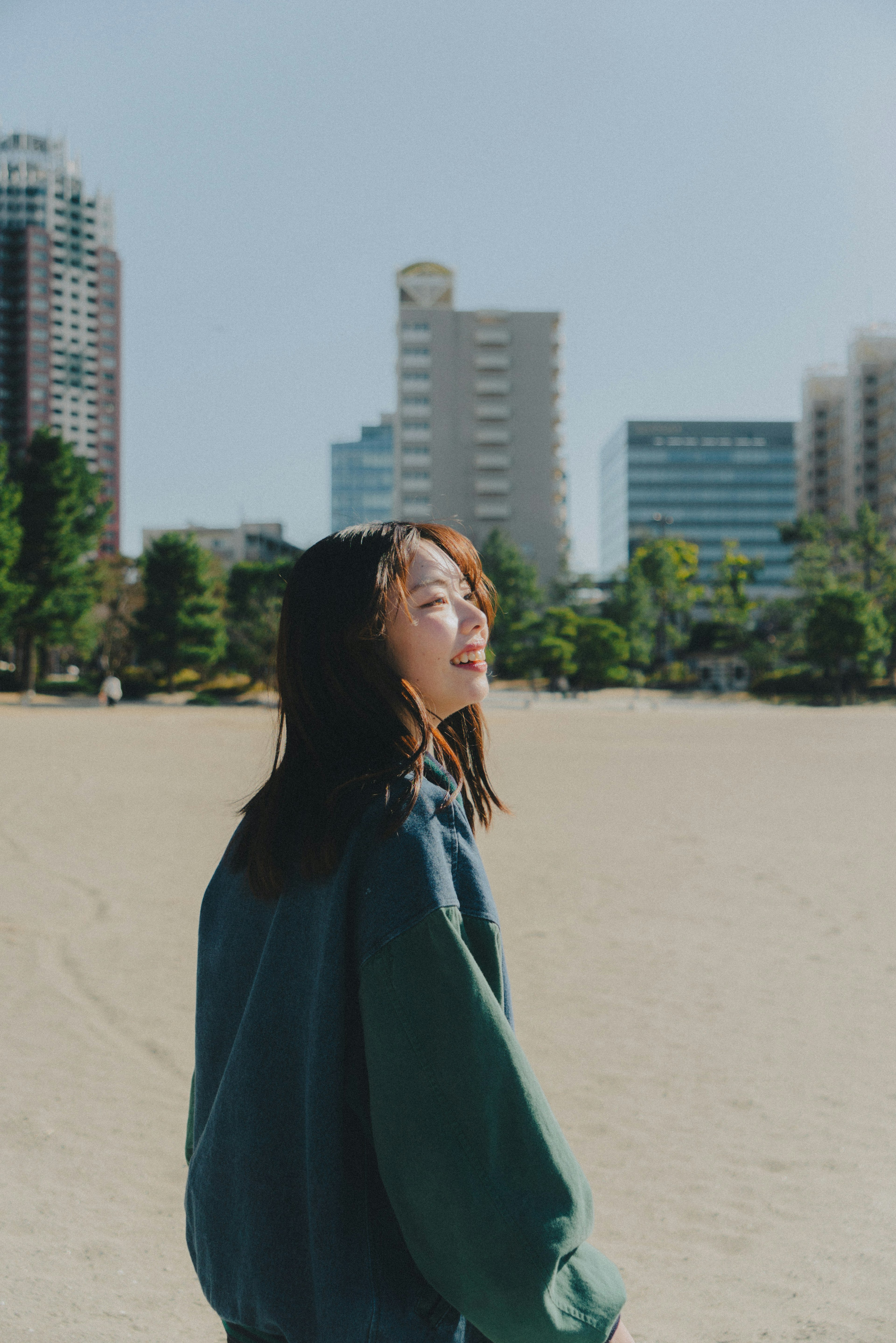 公園で笑顔の女性が振り返る風景