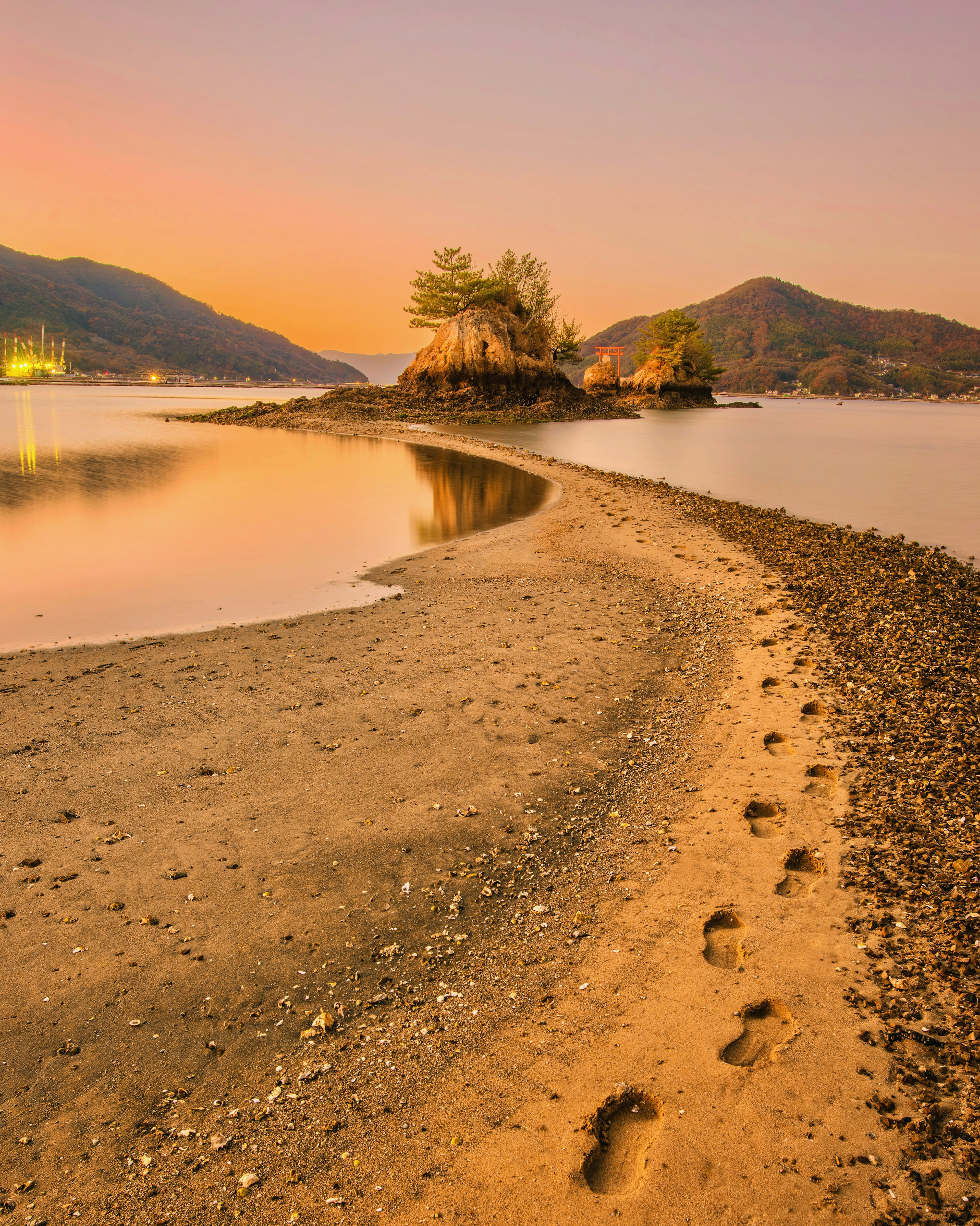 Scenic shoreline with sandy beach and visible footprints