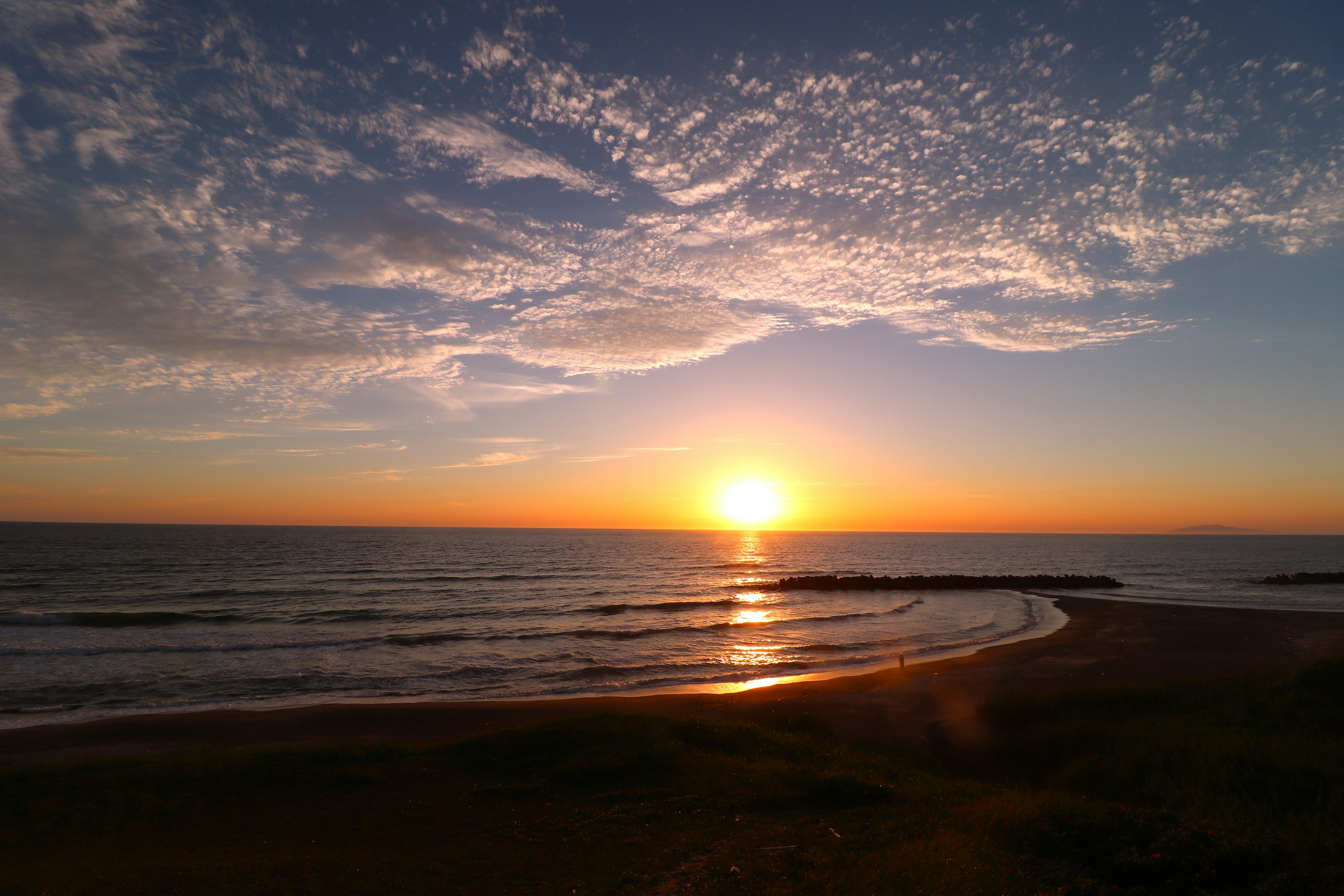 A beautiful landscape with the sun setting over the ocean