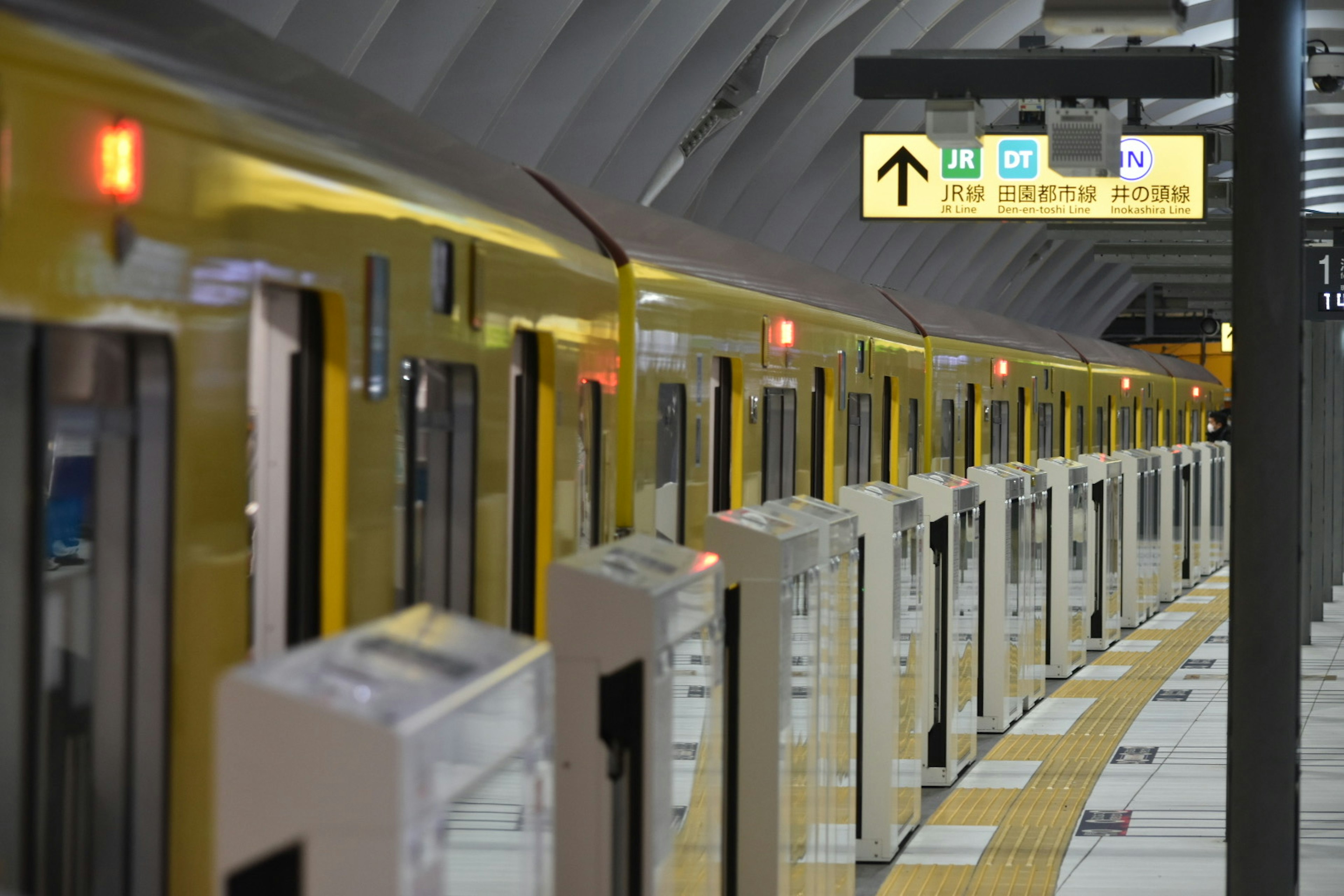 Platform with yellow trains and directional signage