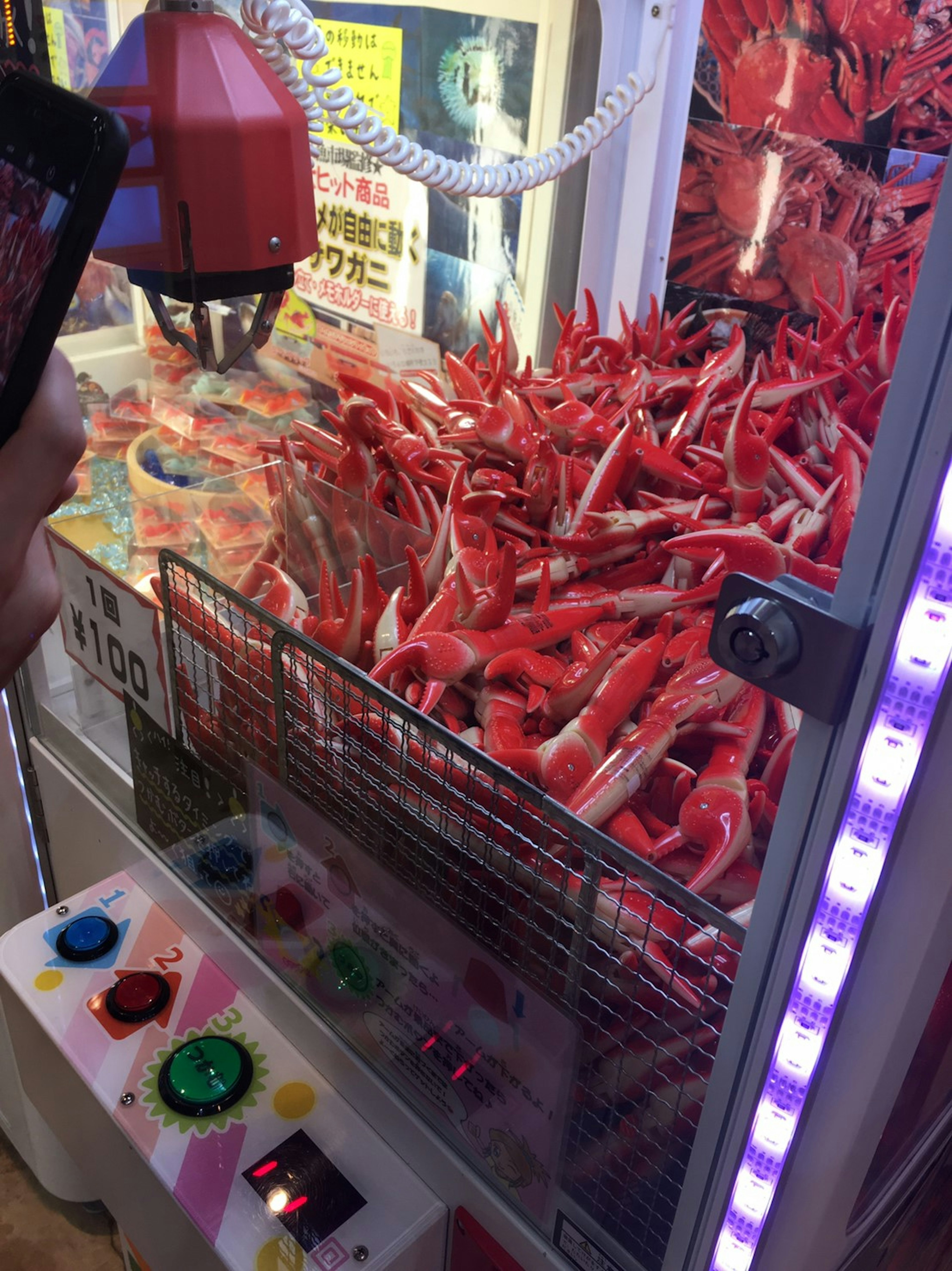 A claw machine filled with numerous red crabs