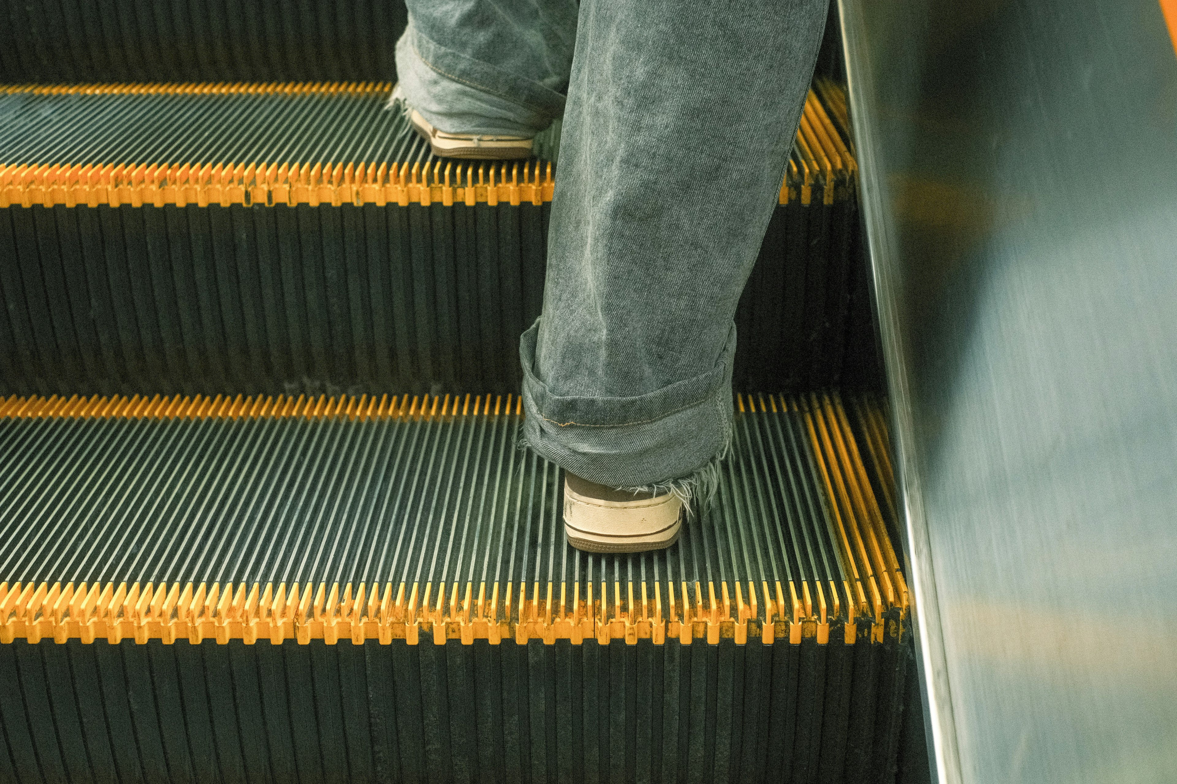 A close-up of feet on an escalator