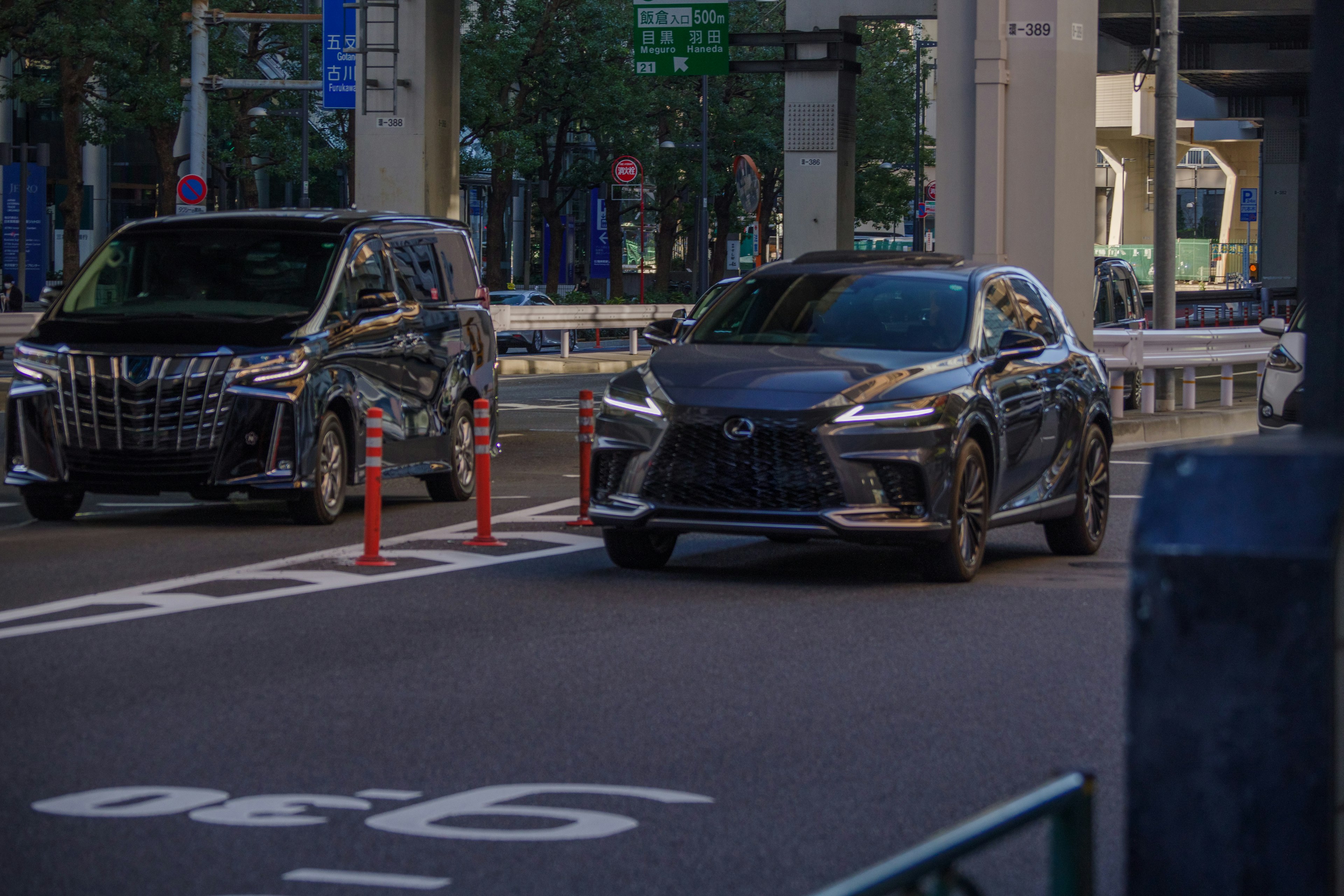 夜の街に停車中の高級車とSUVが並ぶ