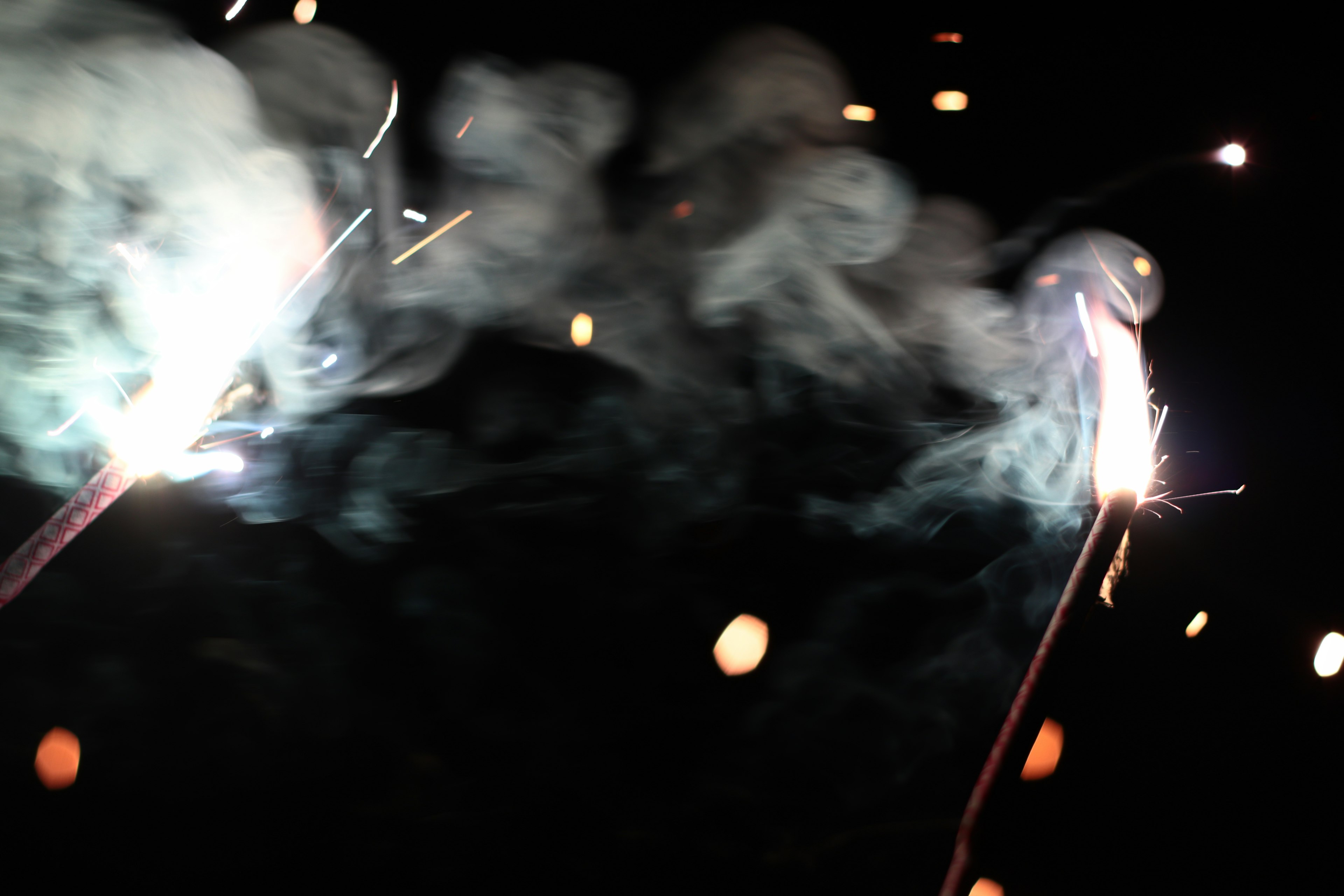 Scena di fuochi d'artificio che scintillano nel cielo notturno con fumi che fluttuano