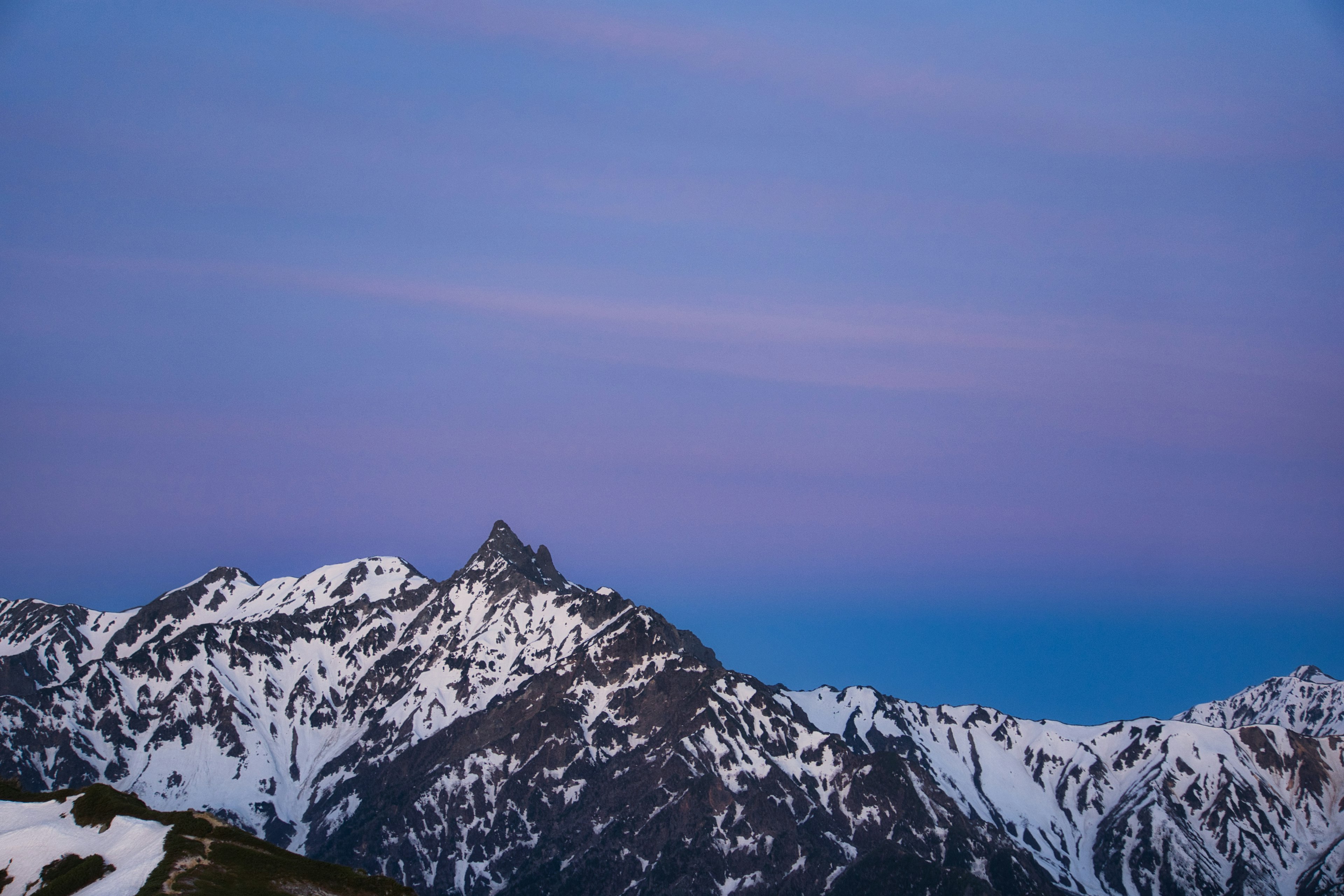 Schneebedeckte Berge unter einem lila Himmel