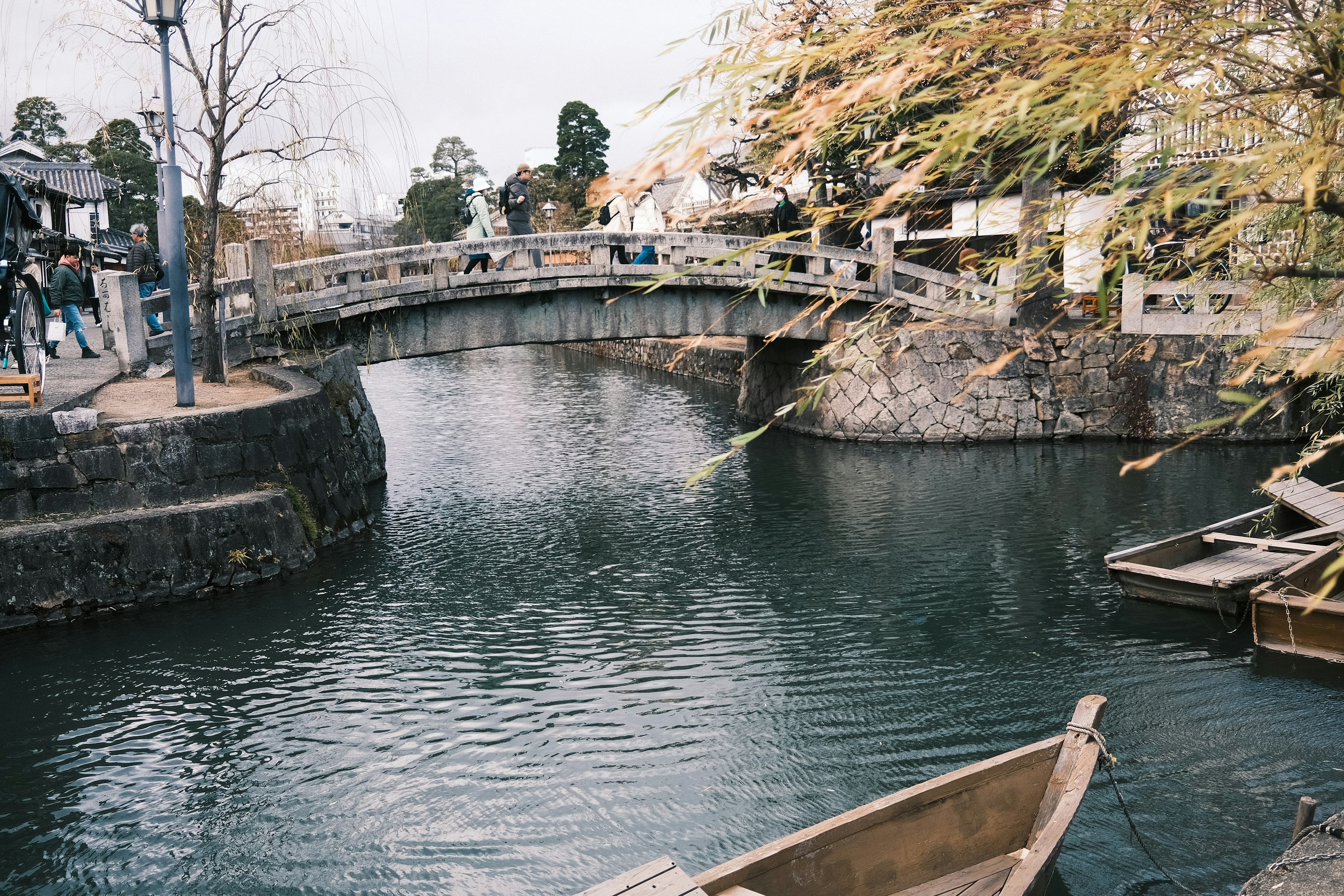 Scenic view of a tranquil waterway with a bridge and autumn foliage