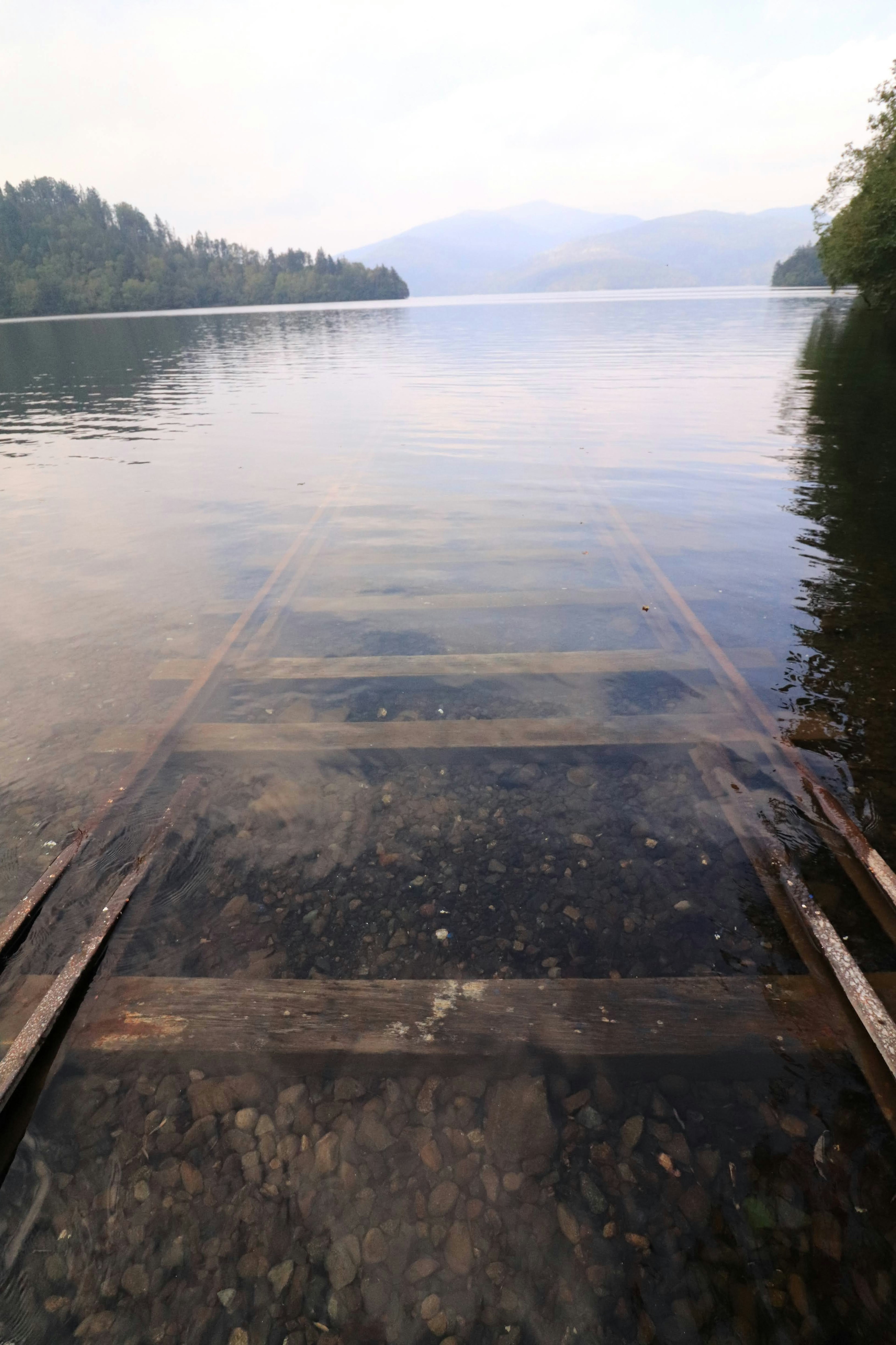 Holzsteg, der in einen ruhigen See führt