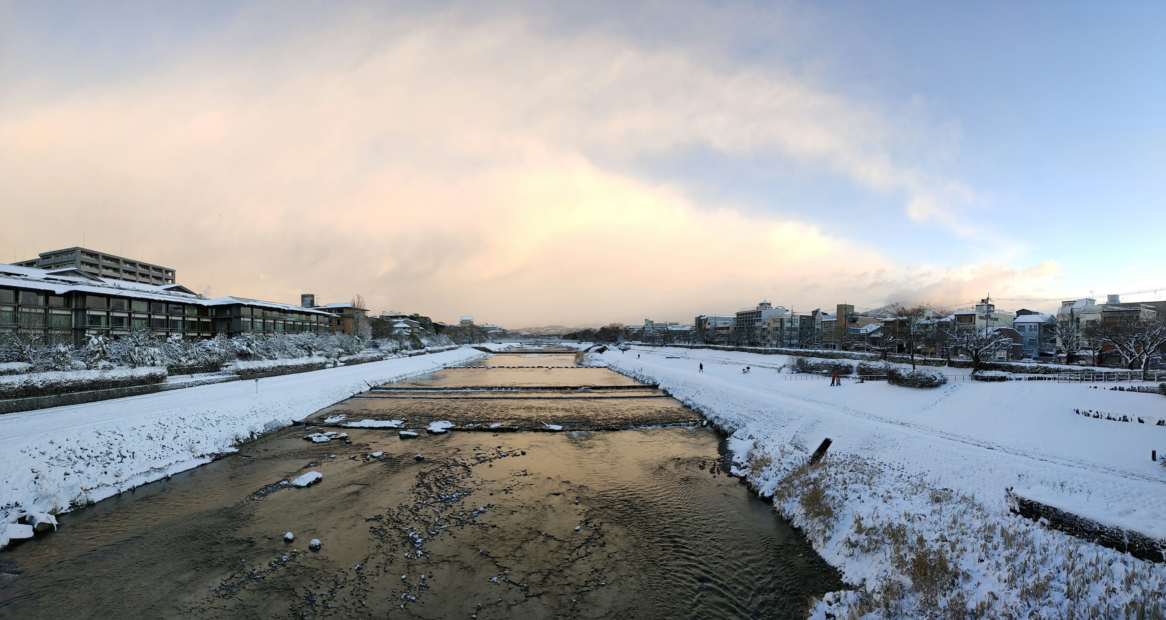 Panoramic view of a snowy river and surrounding landscape