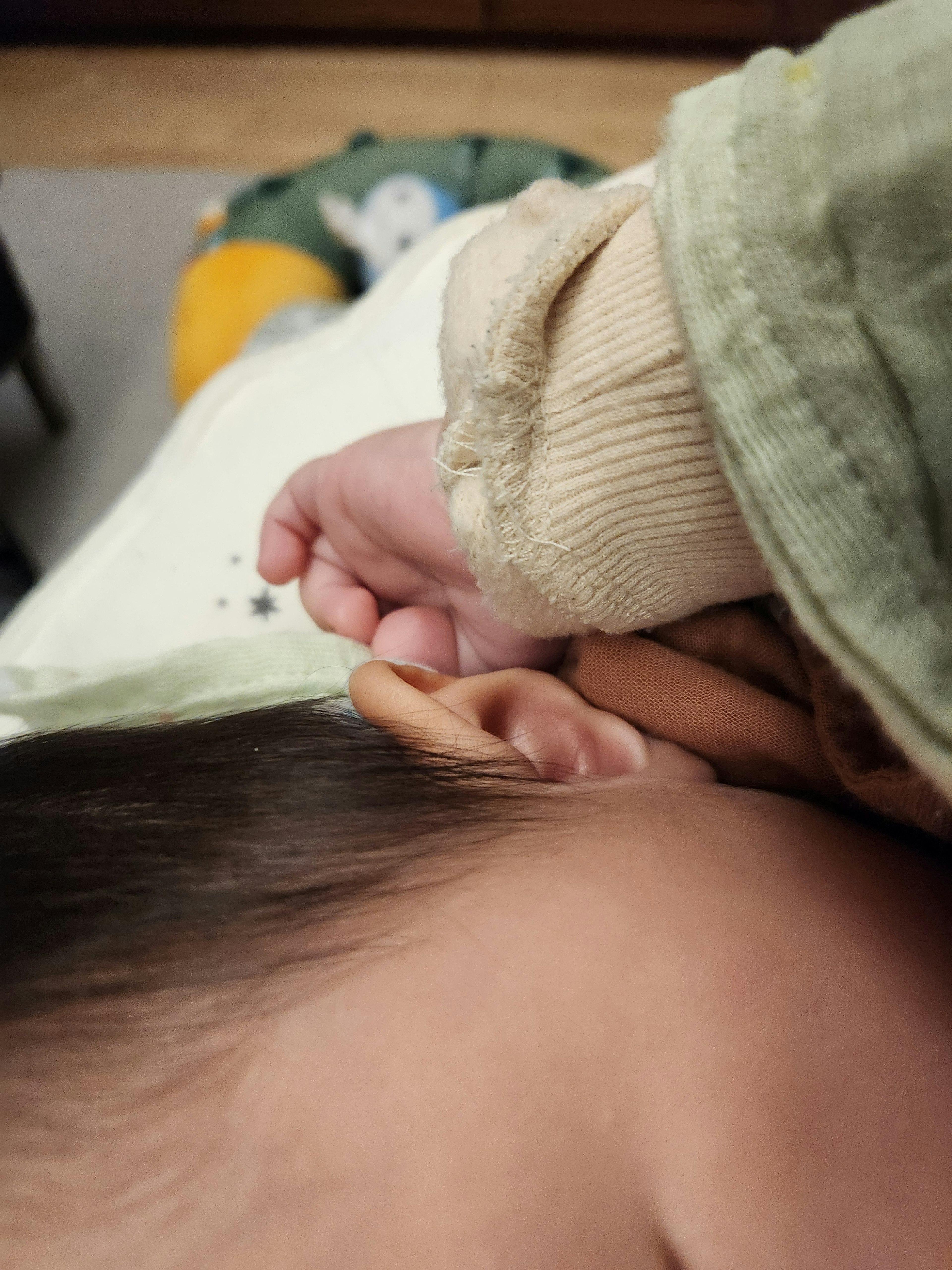 A baby's hand gently touching an ear