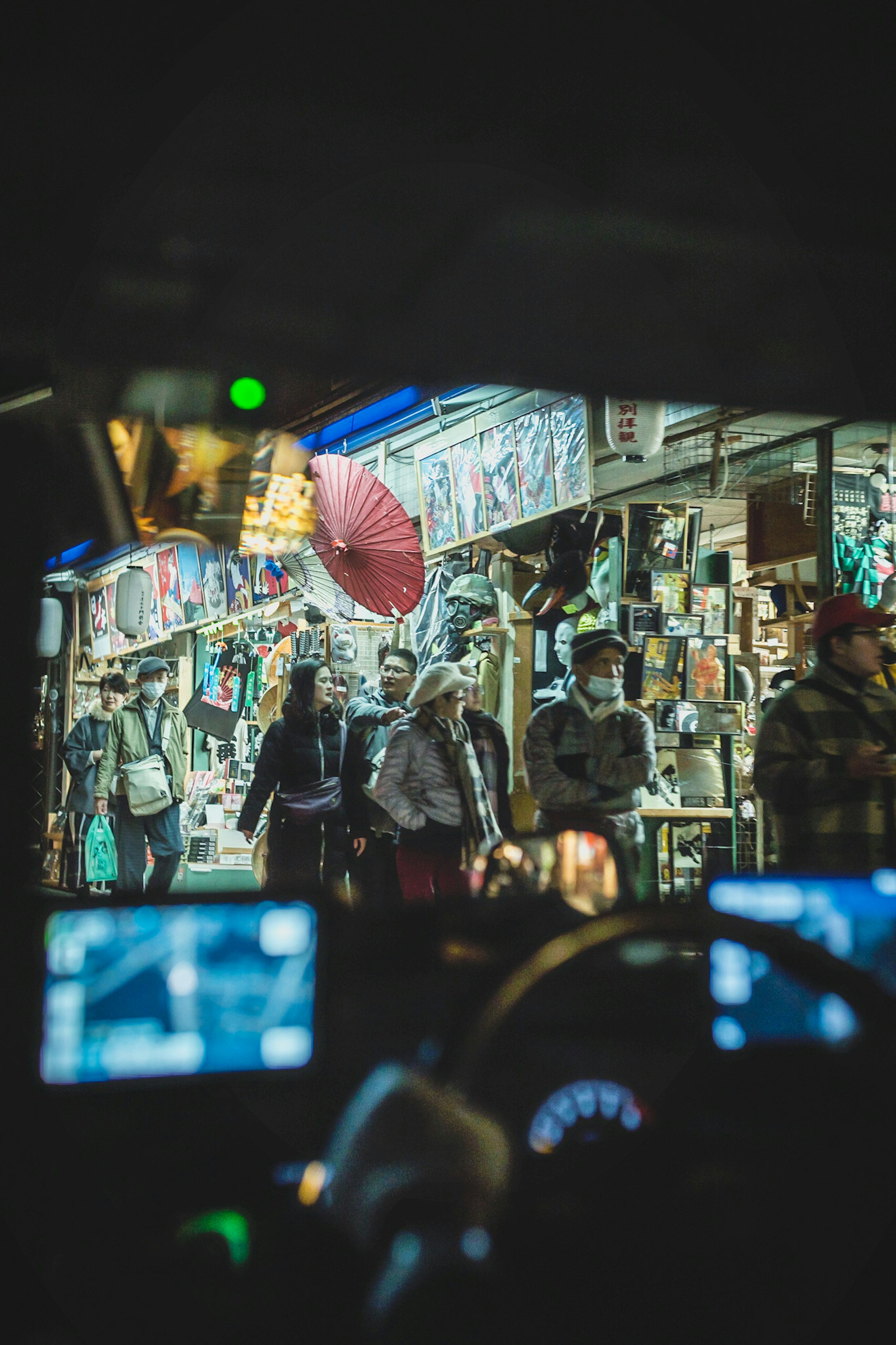 暗い夜の街を歩く人々と色鮮やかな店の看板が見える