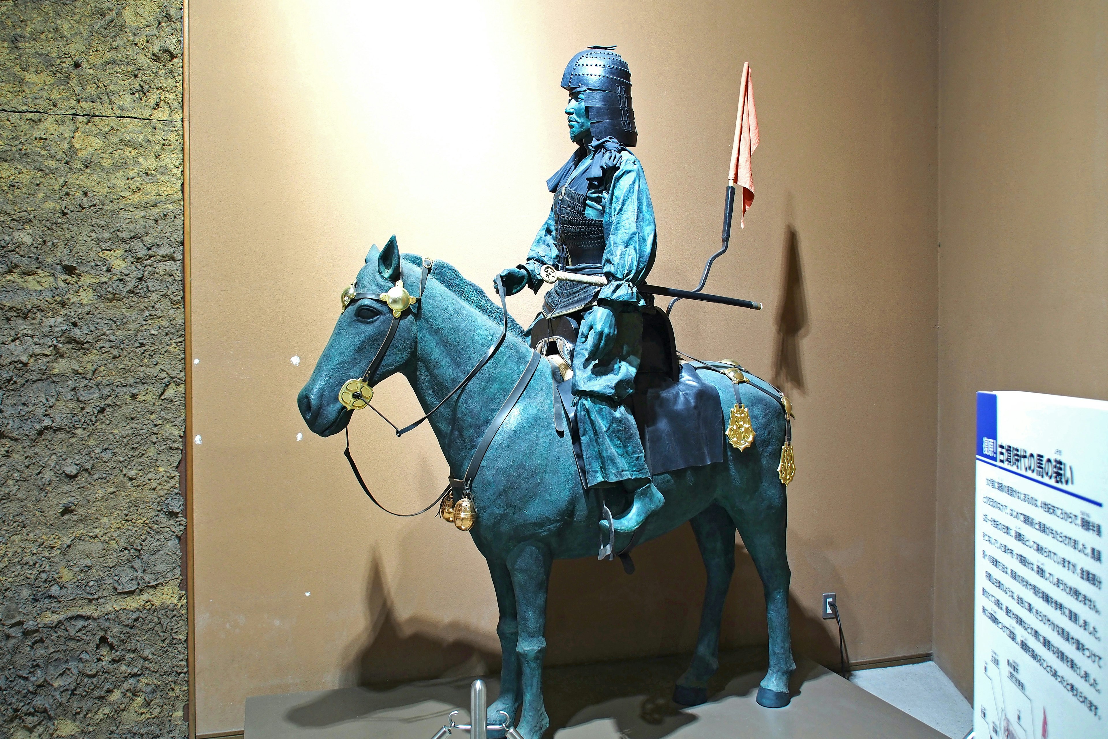 A blue knight and horse statue displayed in a museum interior