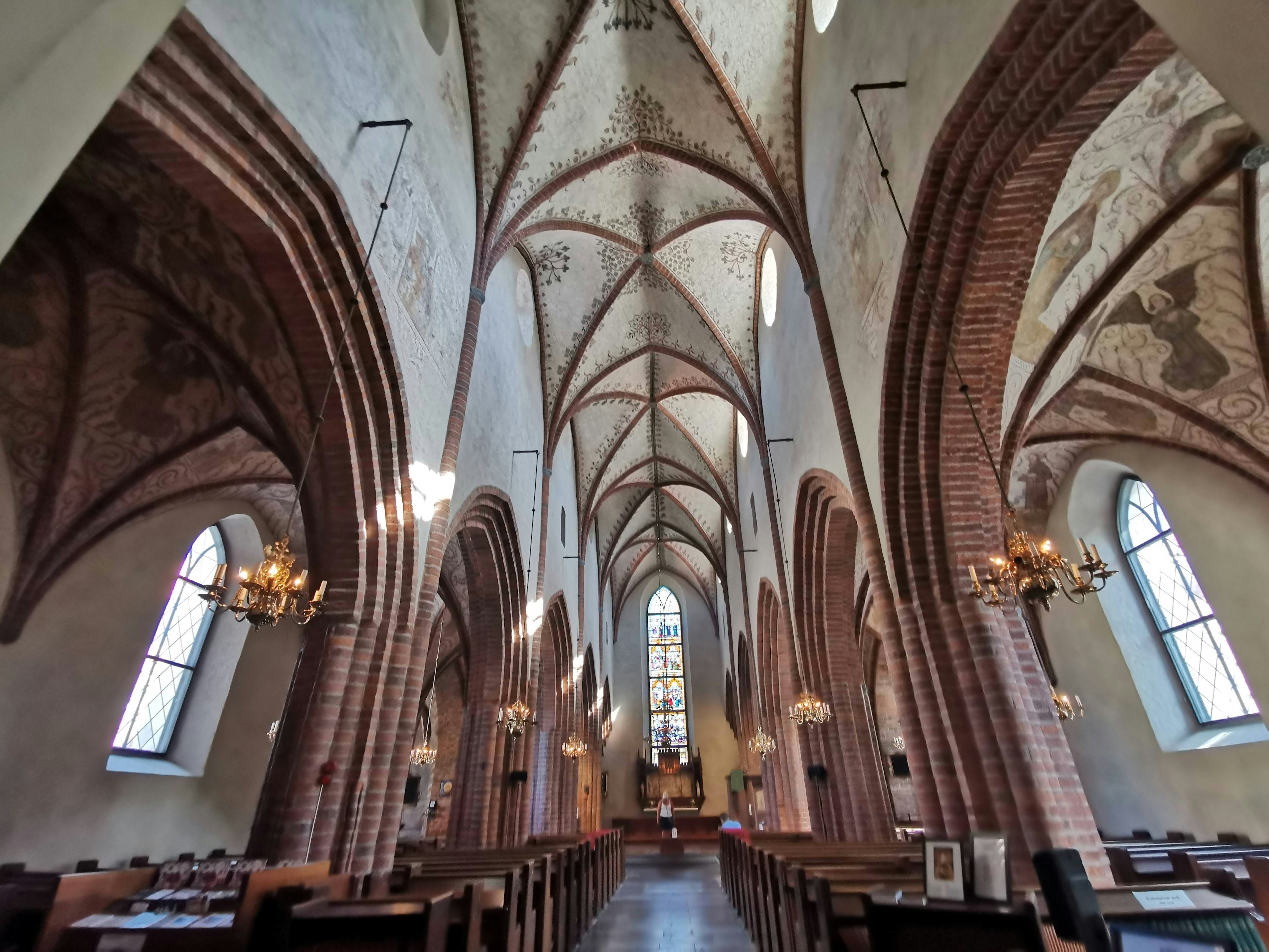 Interior de una iglesia de estilo gótico con arcos alargados y grandes ventanas