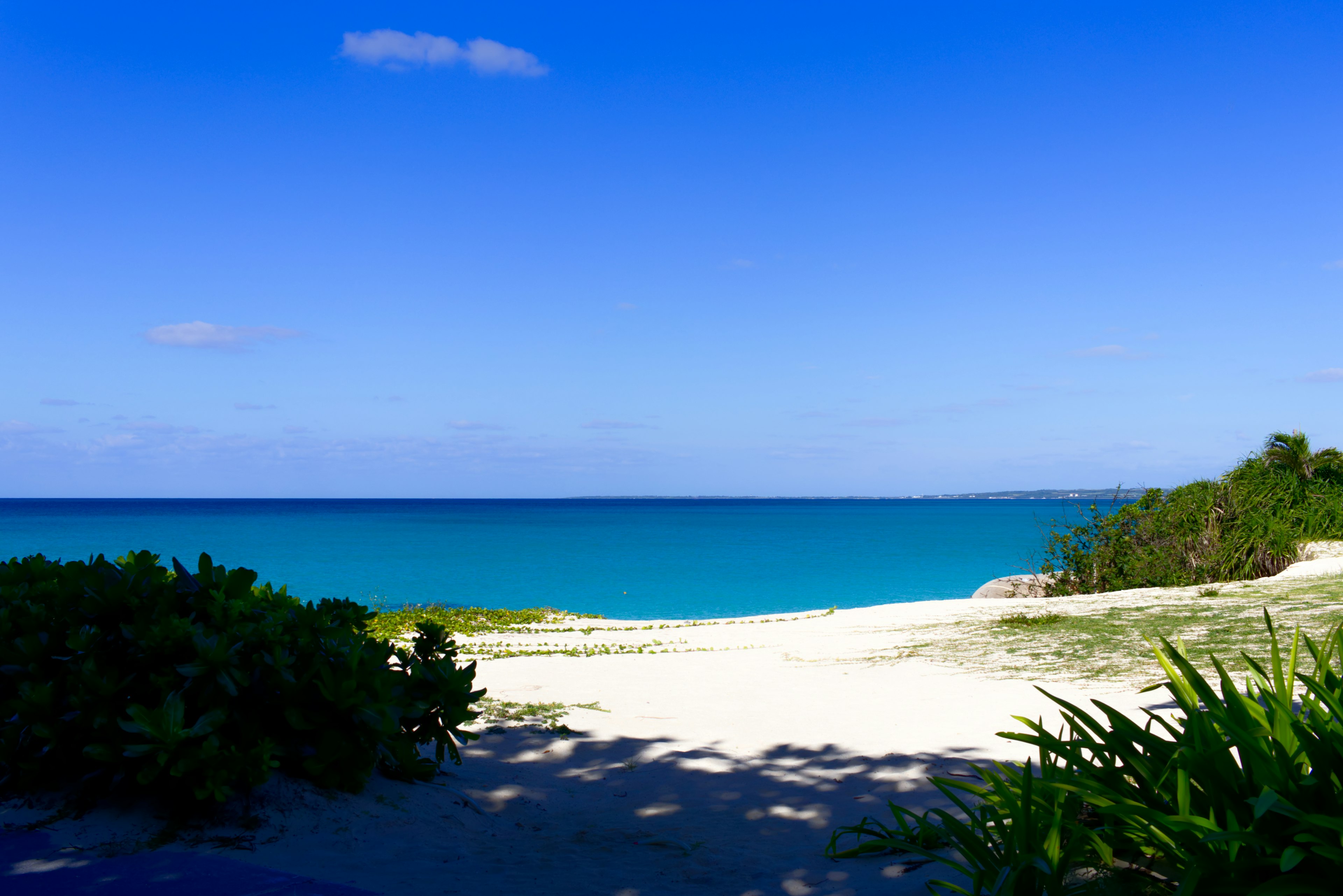 ทิวทัศน์ชายหาดสวยงามพร้อมทะเลสีน้ำเงินและทรายขาว