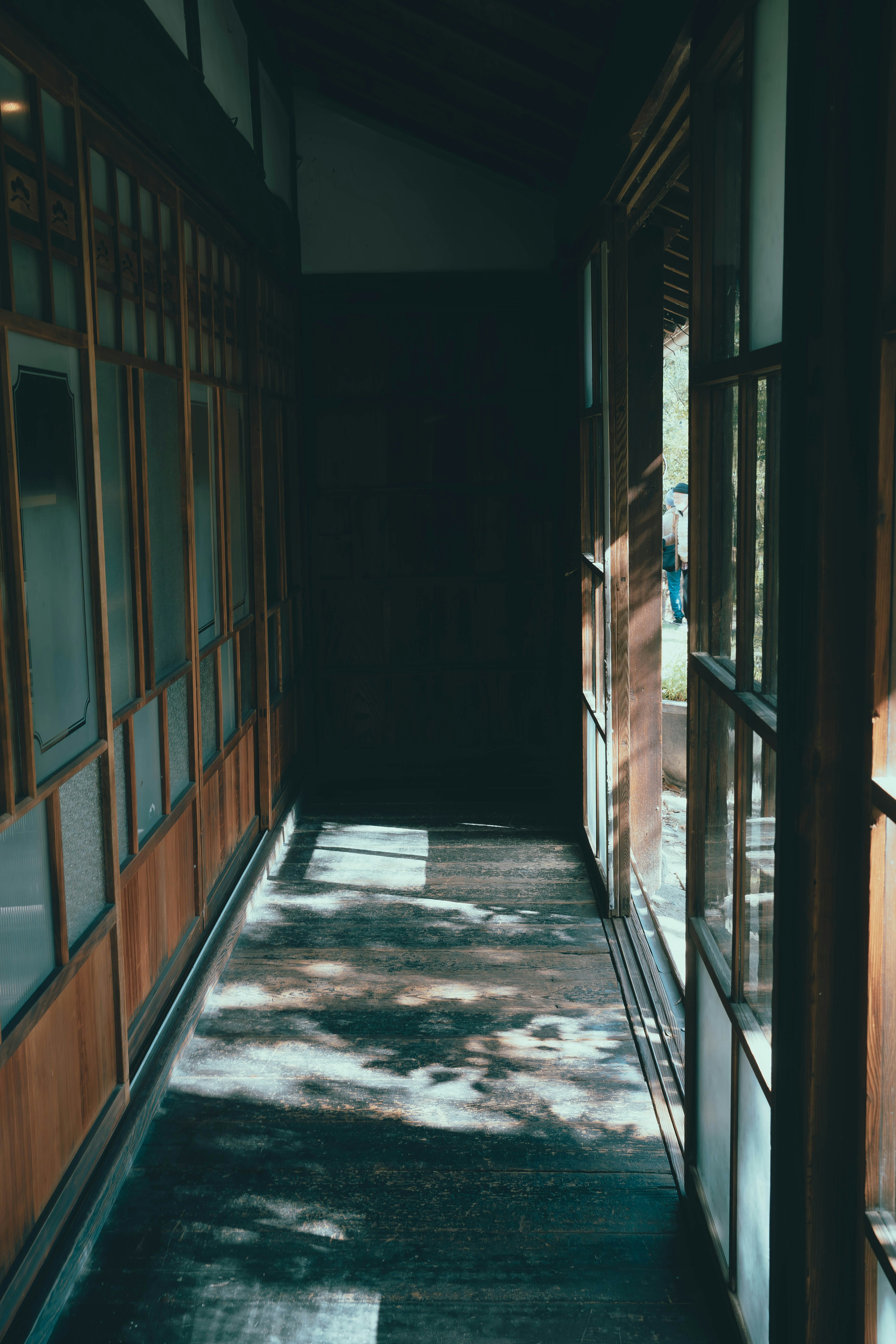 Couloir faiblement éclairé avec des murs en bois et des portes en verre